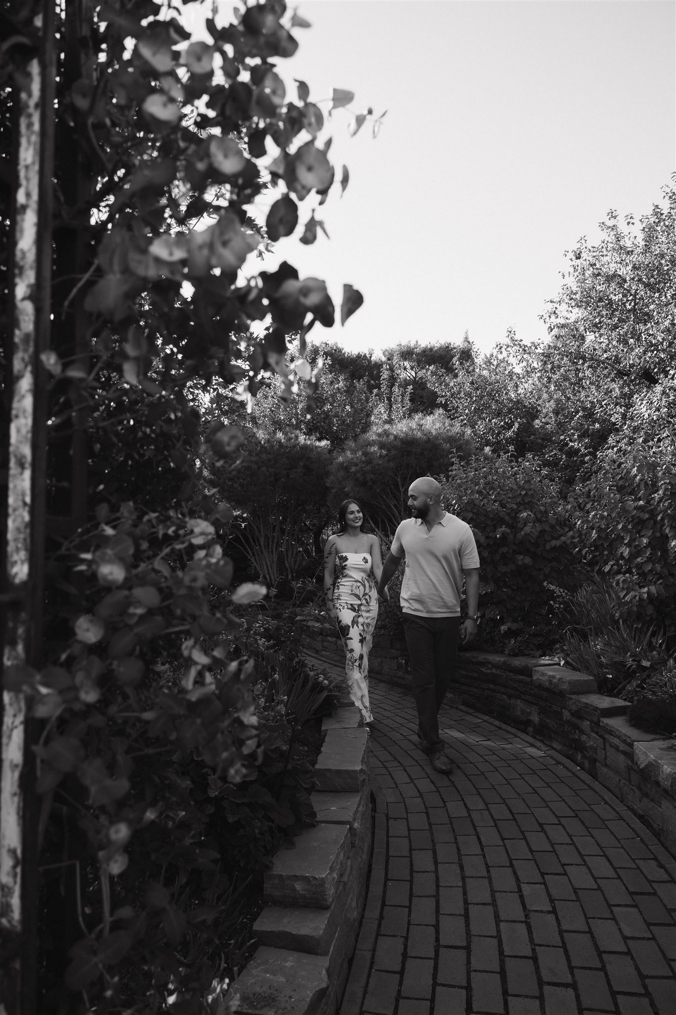 a couple walking on a cobblestone path during their Denver Botanic Gardens Engagement Photos