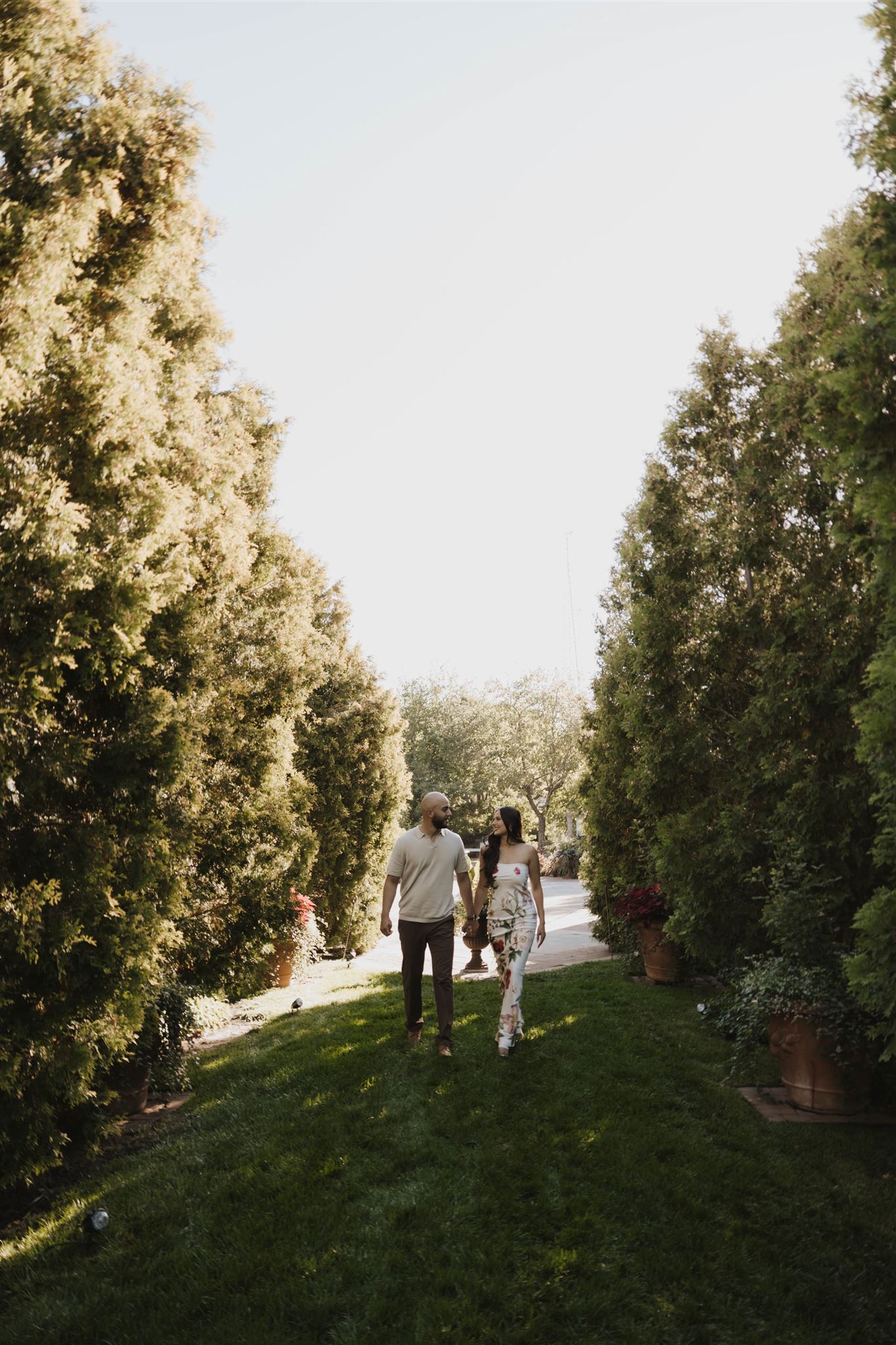 a couple walking through the tall trees during their Denver Botanic Gardens Engagement Photos