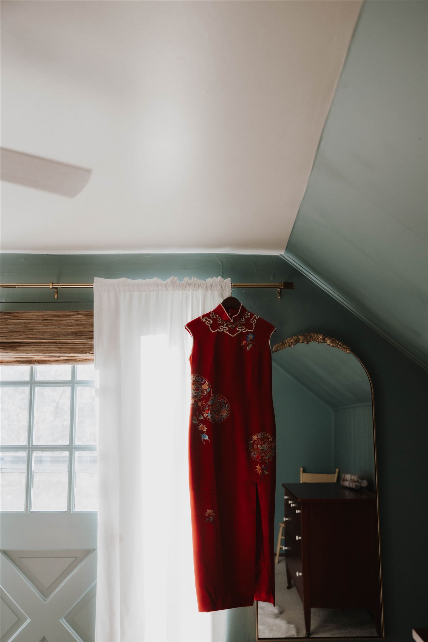 bride's second dress hanging from the curtain at the airbnb