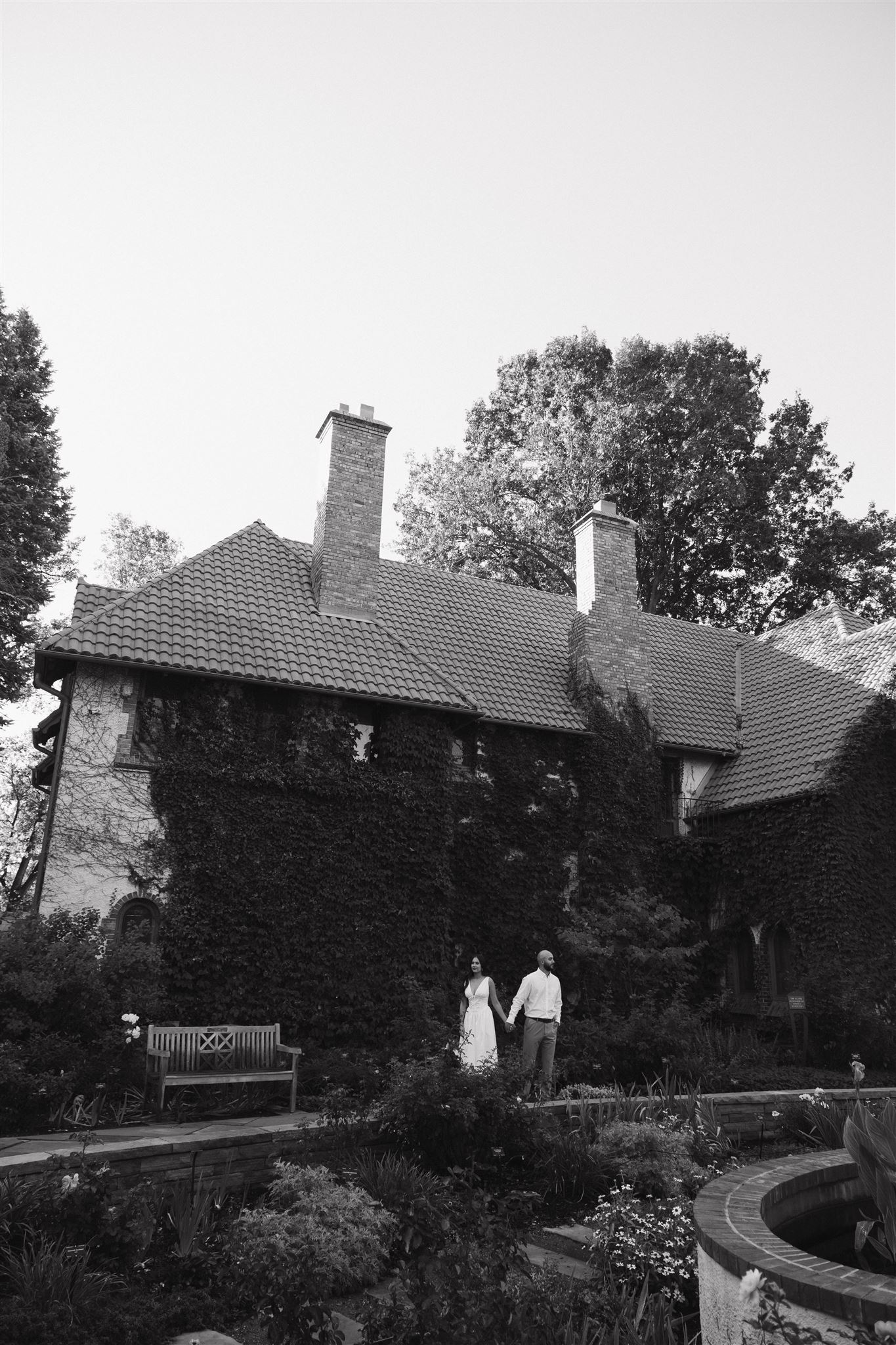 a couple holding hands by the ivy covered wall during Denver Botanic Gardens Engagement Photos