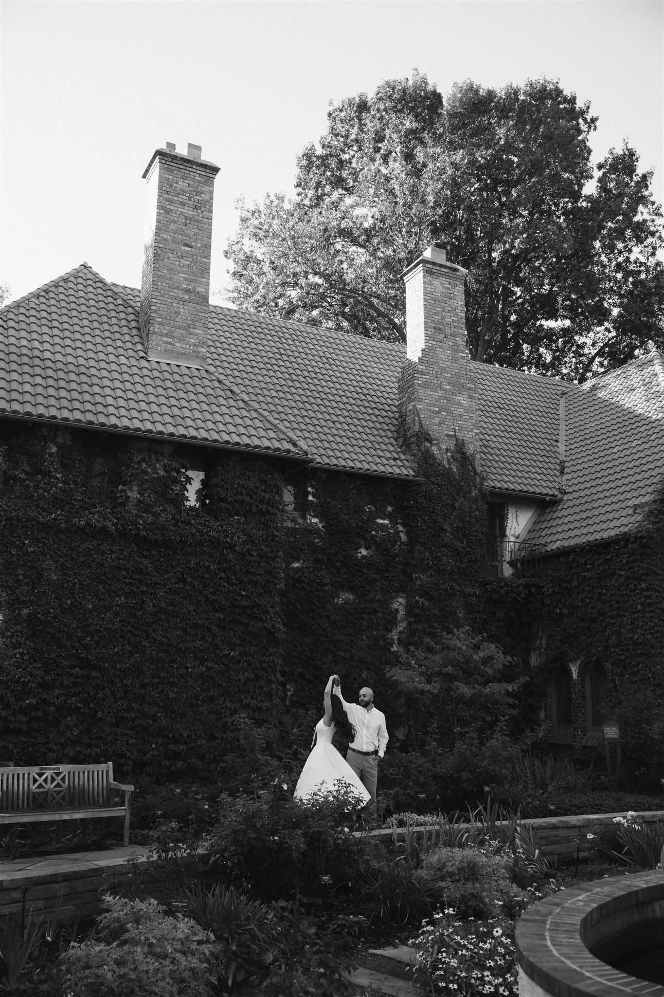 a couple dancing by a fountain in the garden during Denver Botanic Gardens Engagement Photos