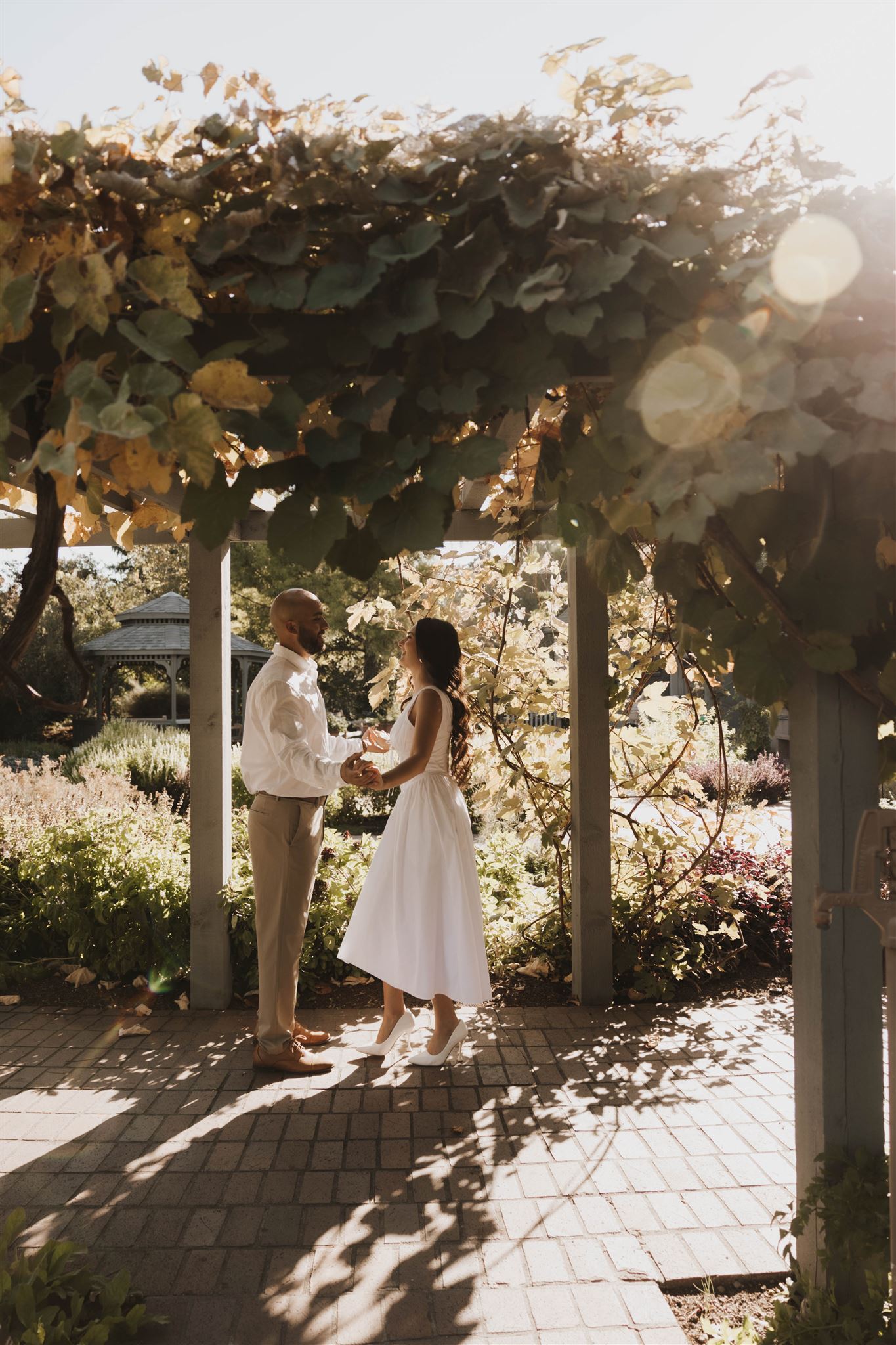 newly engaged couple dancing under a trellis during Denver Botanic Gardens Engagement Photos