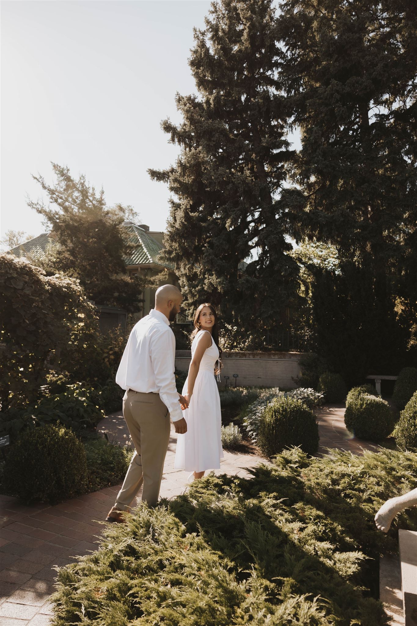 a couple walking through the garden together 