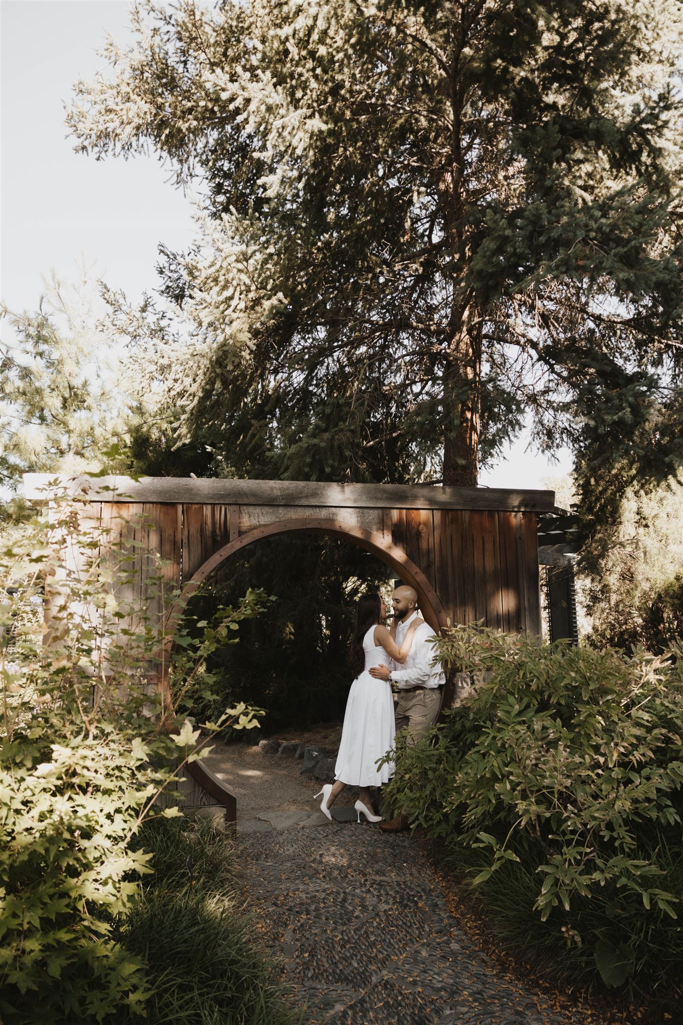 a couple kissing against an arch at Denver Botanic Gardens 