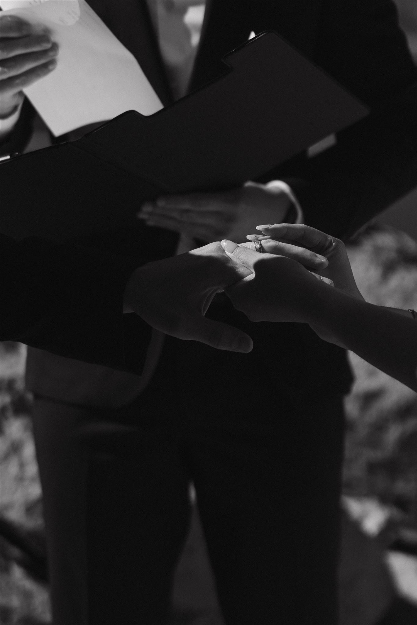 wedding couple putting rings on each other during Sapphire Point Elopement