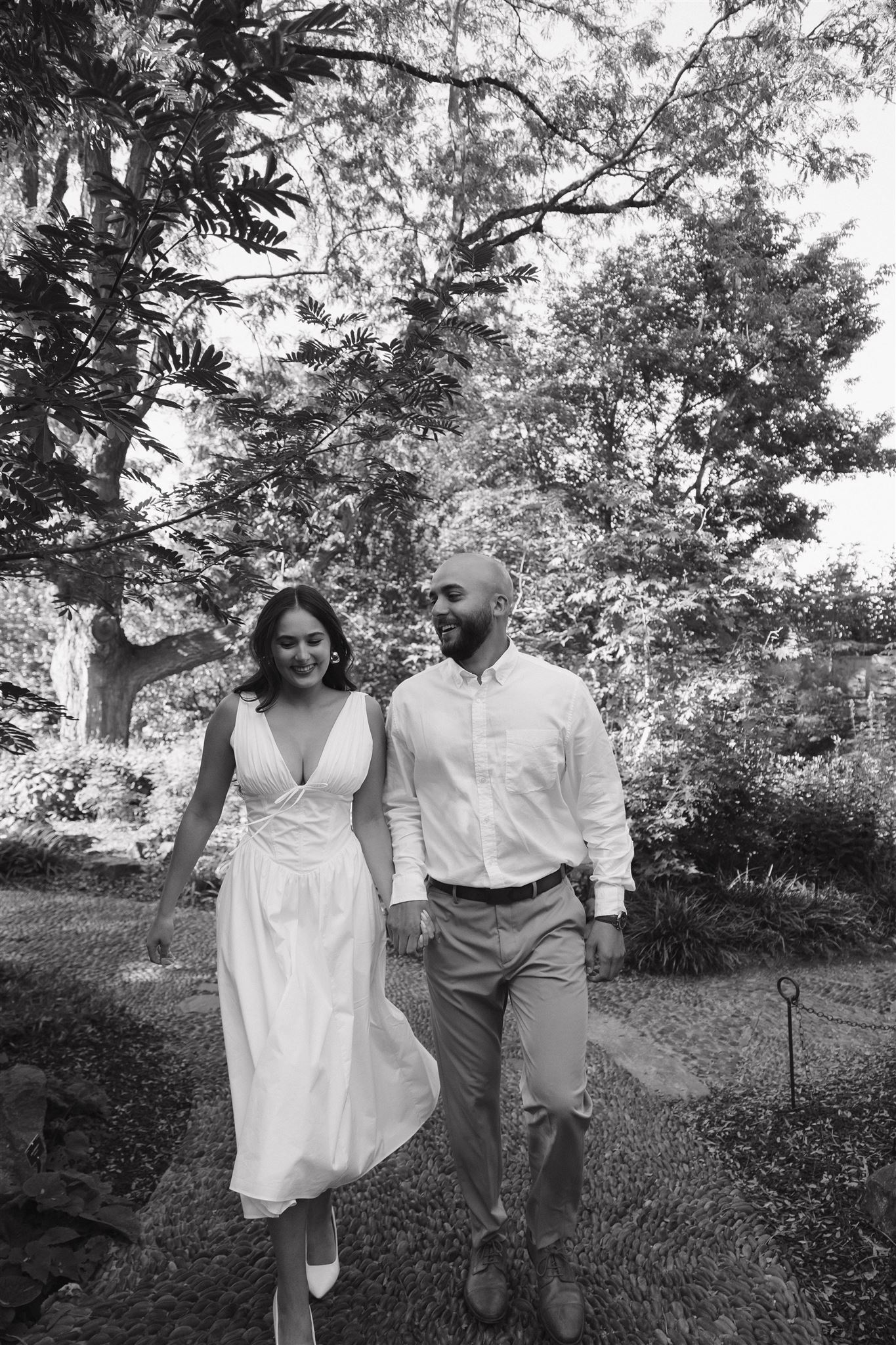 a couple walking hand in hand down a path during their Denver Botanic Gardens Engagement Photos