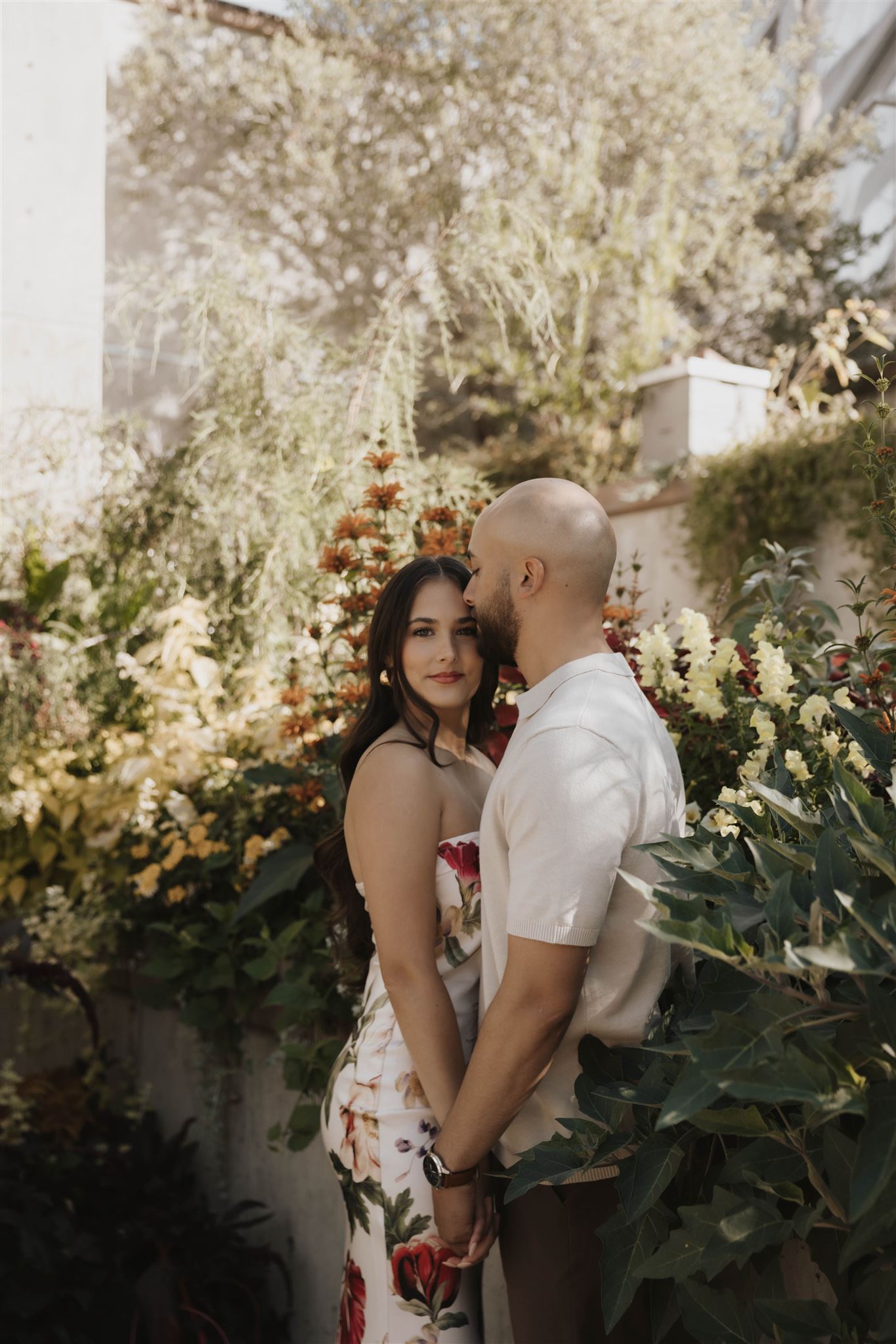 a man kissing the side of a woman's face during their engagement photos 