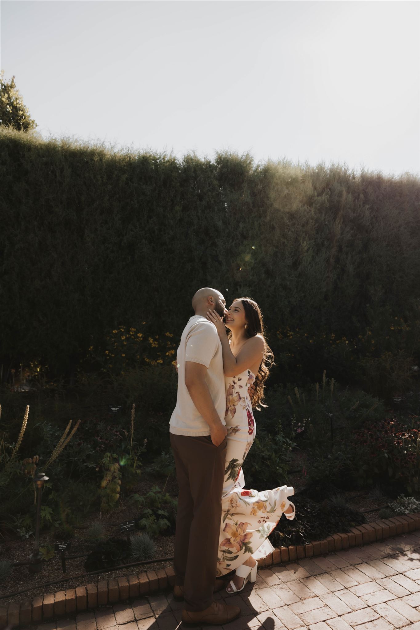 couple kissing and laughing on a path at Denver Botanic Gardens 