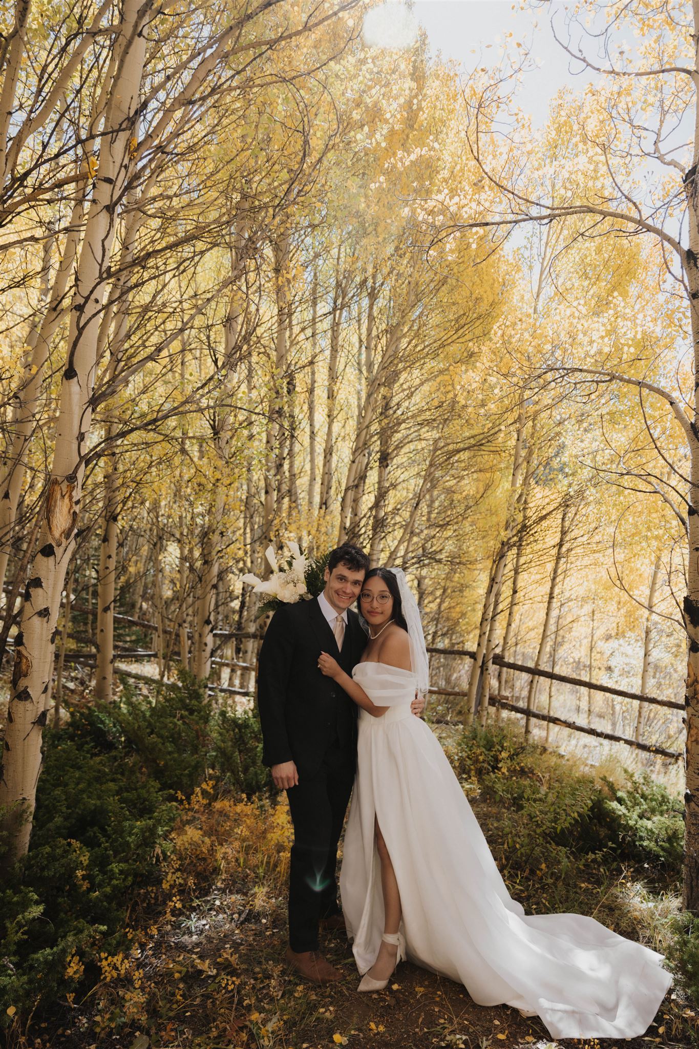 bride and groom portrait with the fall leaves surrounding them