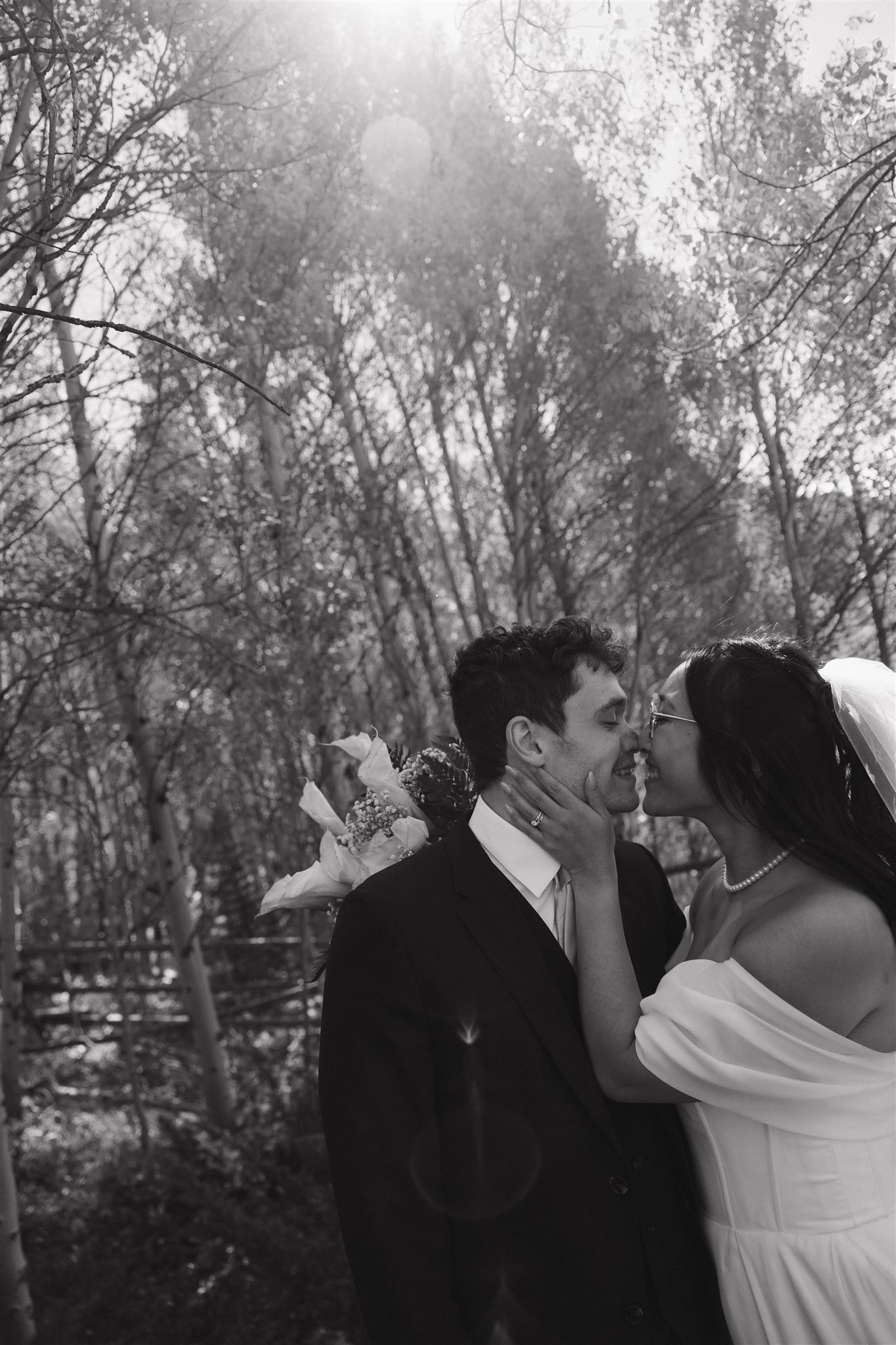 bride and groom kissing in the woods 