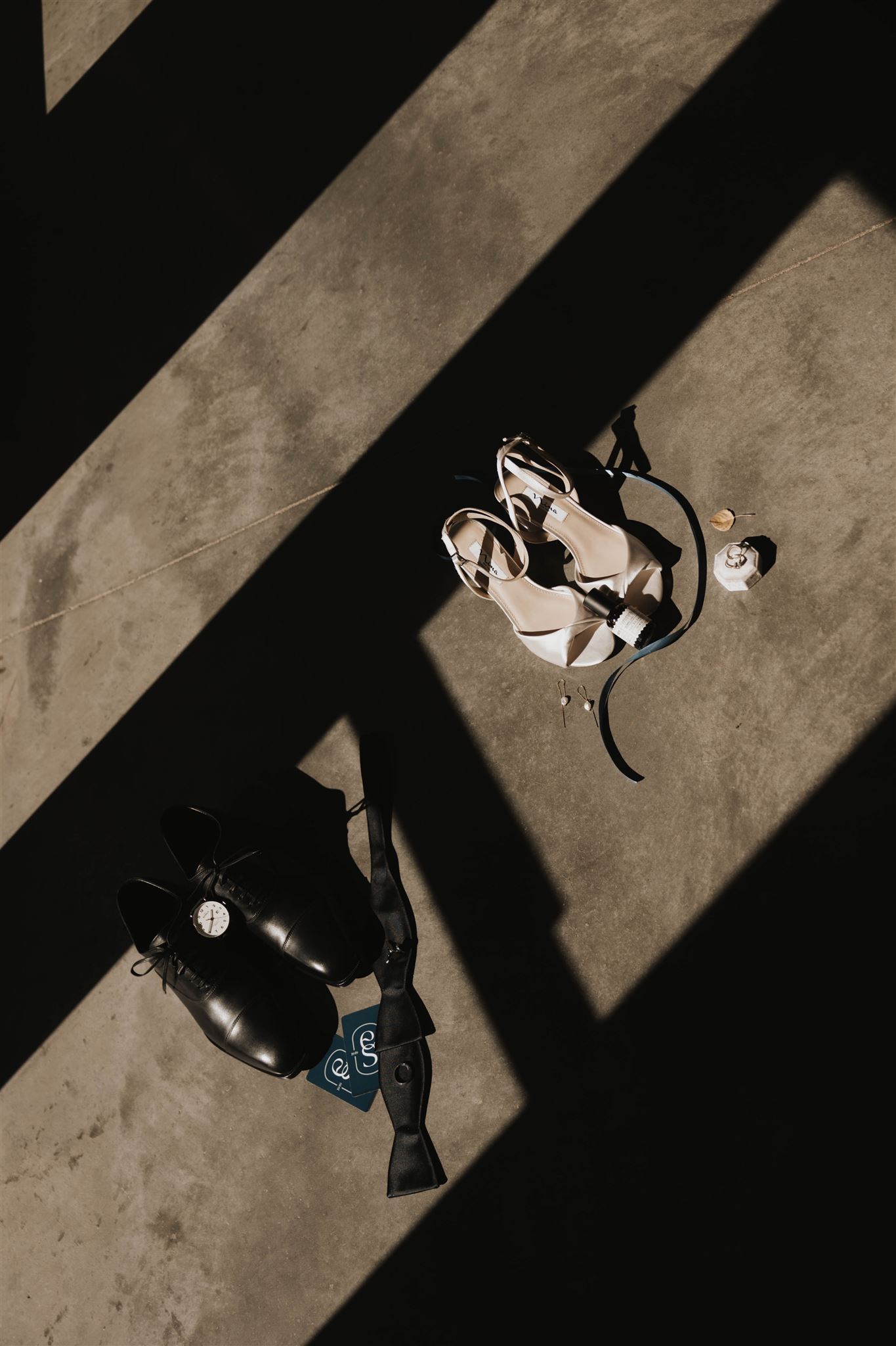 bride and groom's shoes on the floor with shadows 