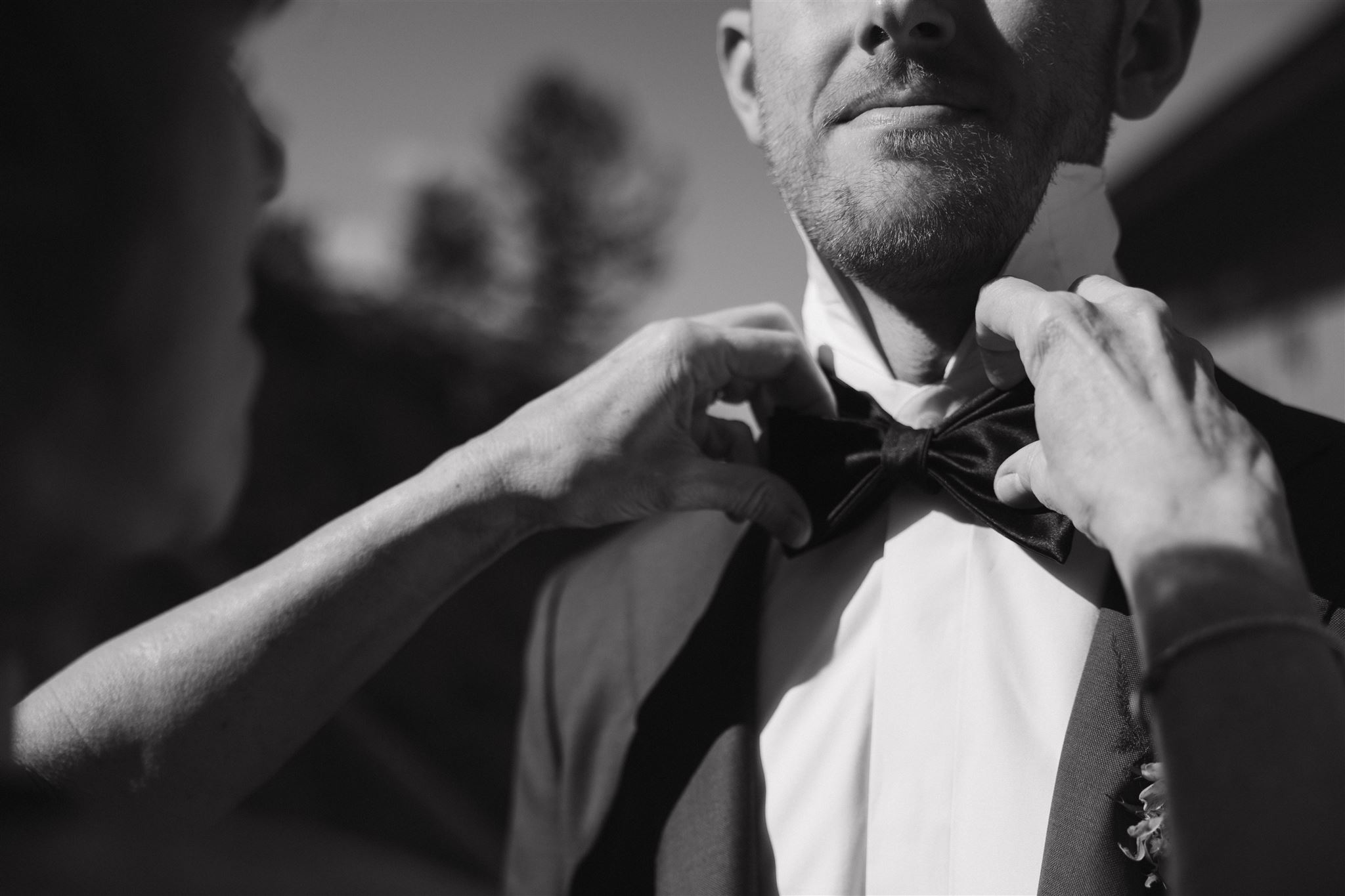 groom's mom helping with his bowtie 