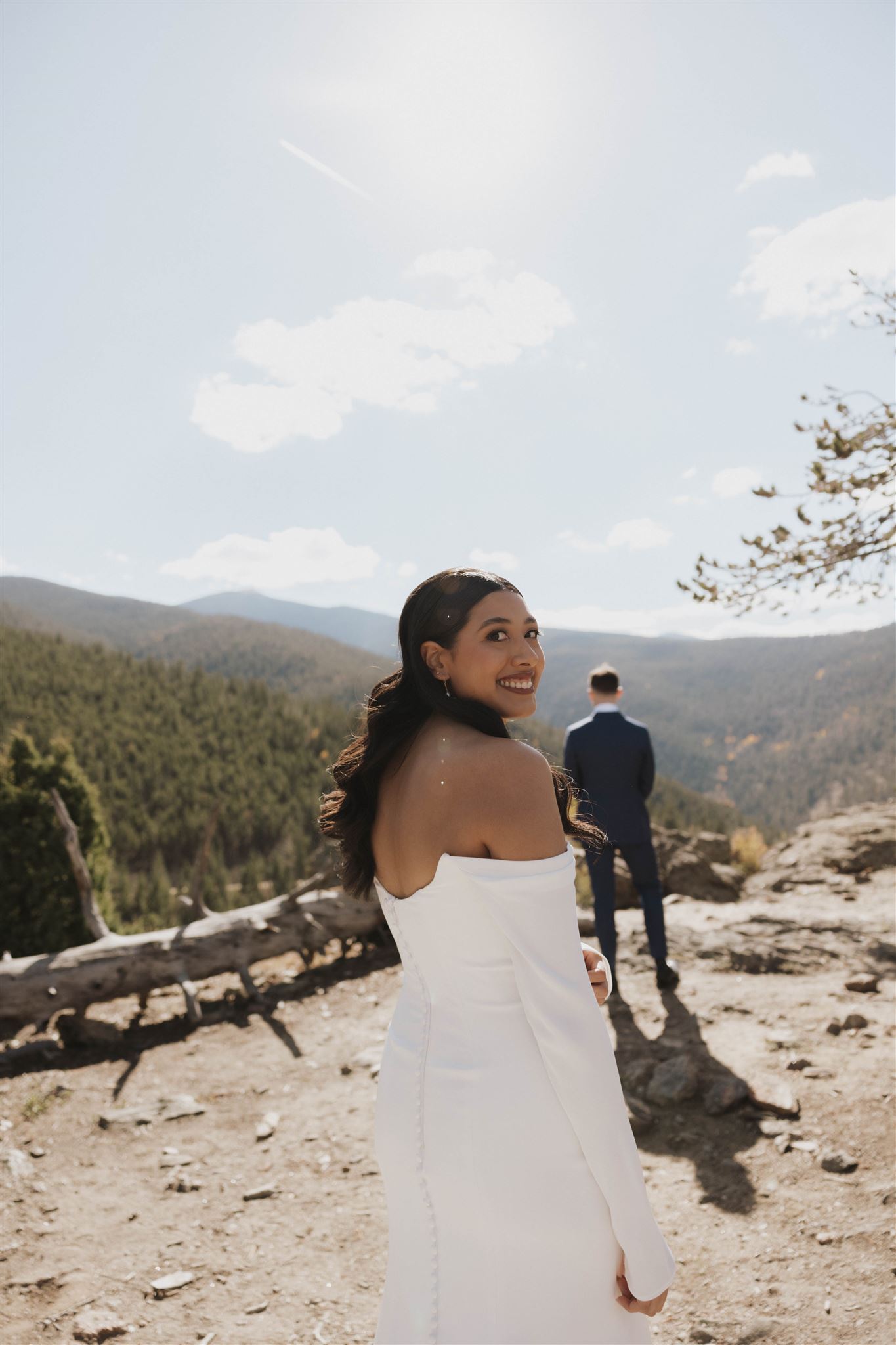 bride standing behind the groom for the first look