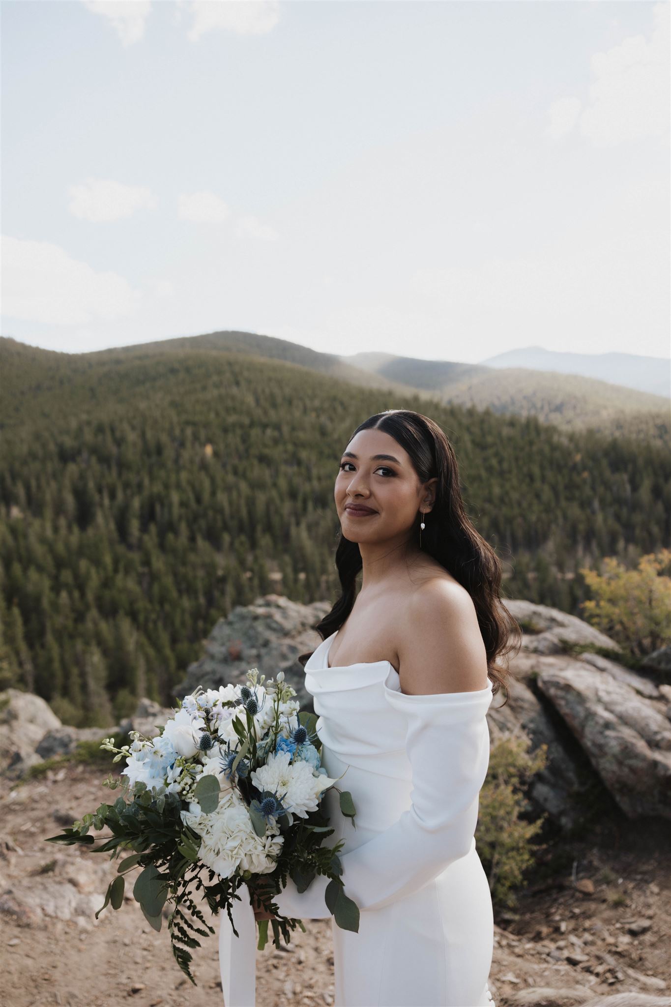 bride holding her bouquet with the mountains behind her 