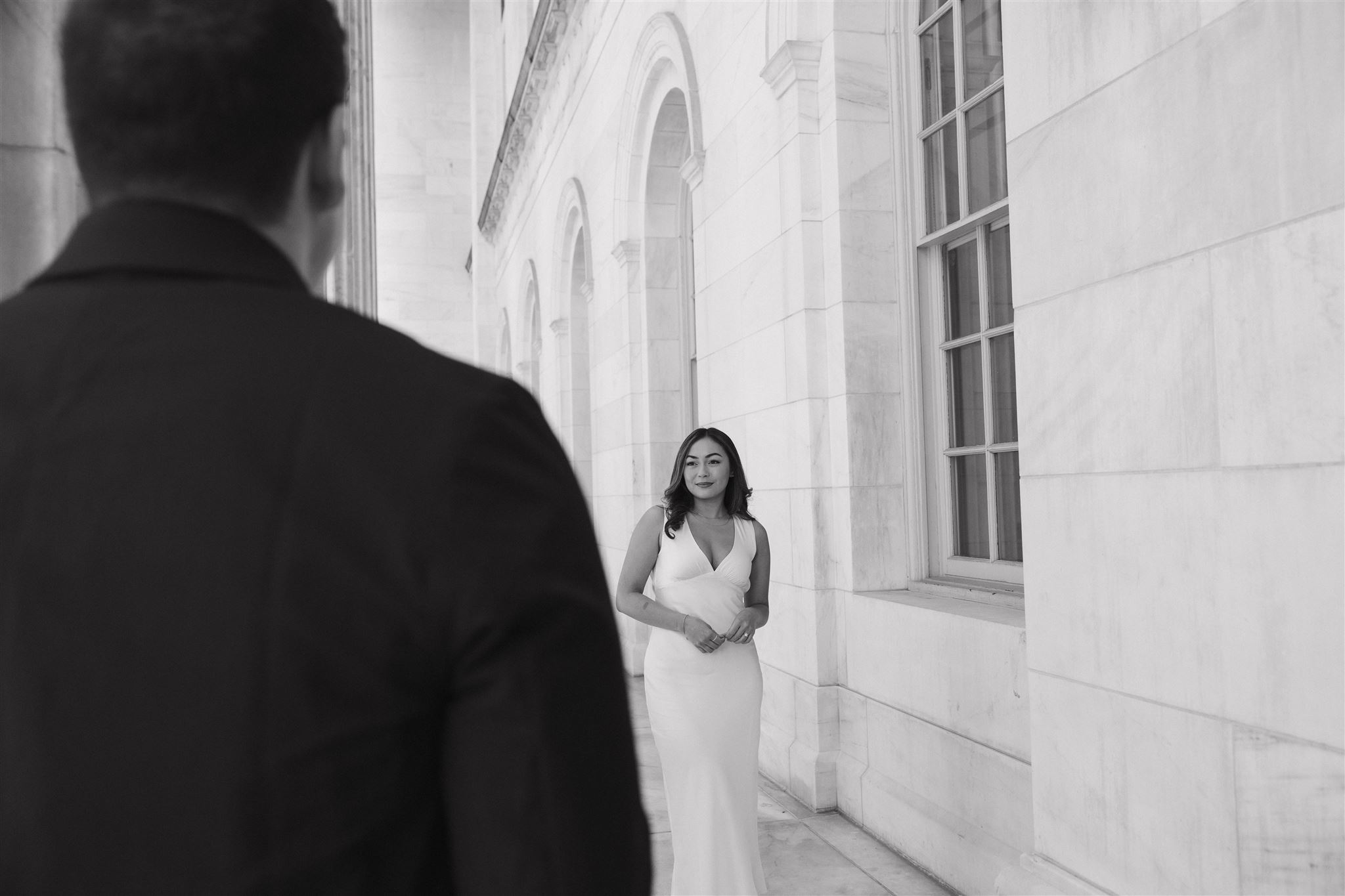 a man with his back to the camera and a woman in front of him looking at him during their Elegant Engagement Photos