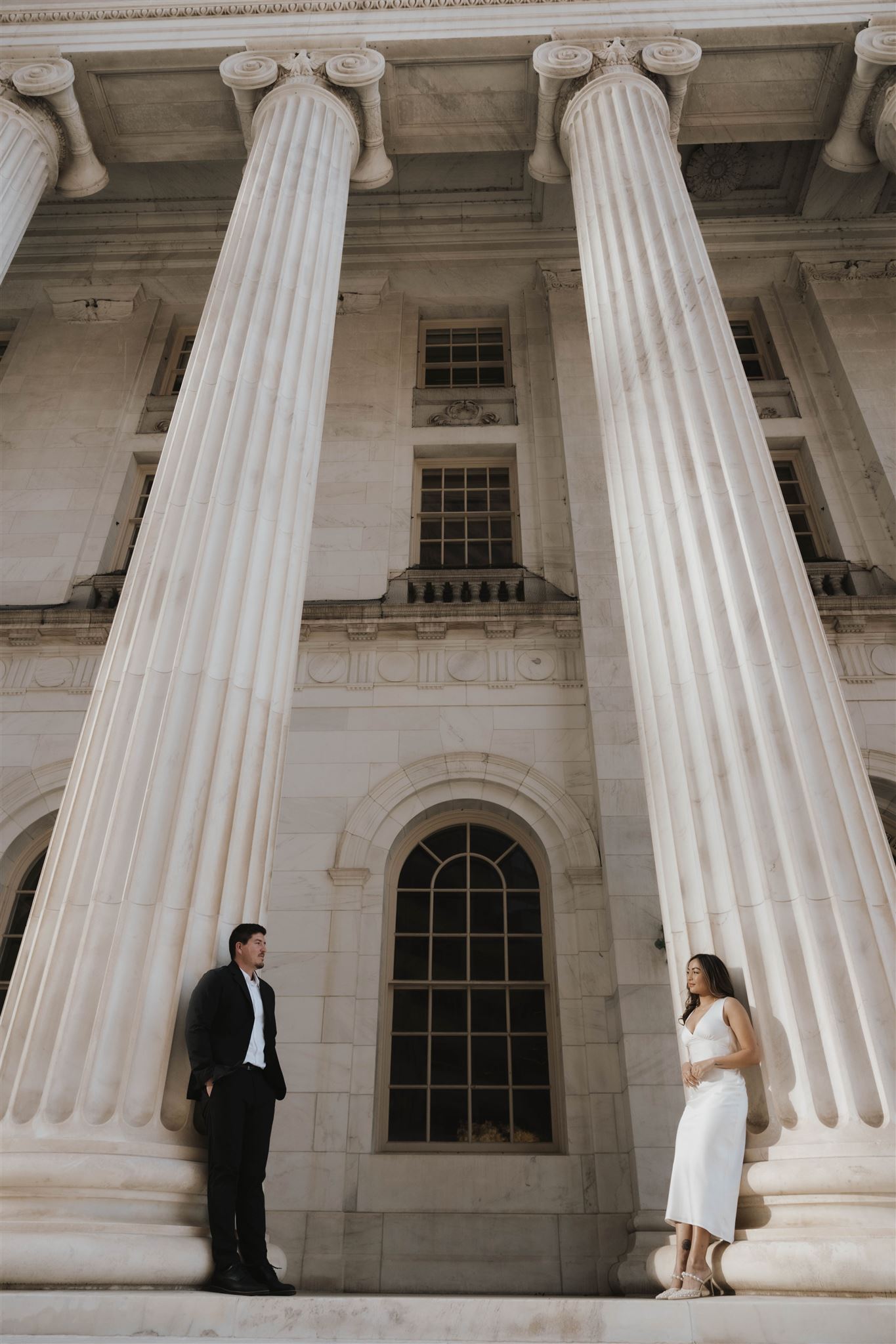 newly engaged couple leaning against some pillars for their Elegant Engagement Photos