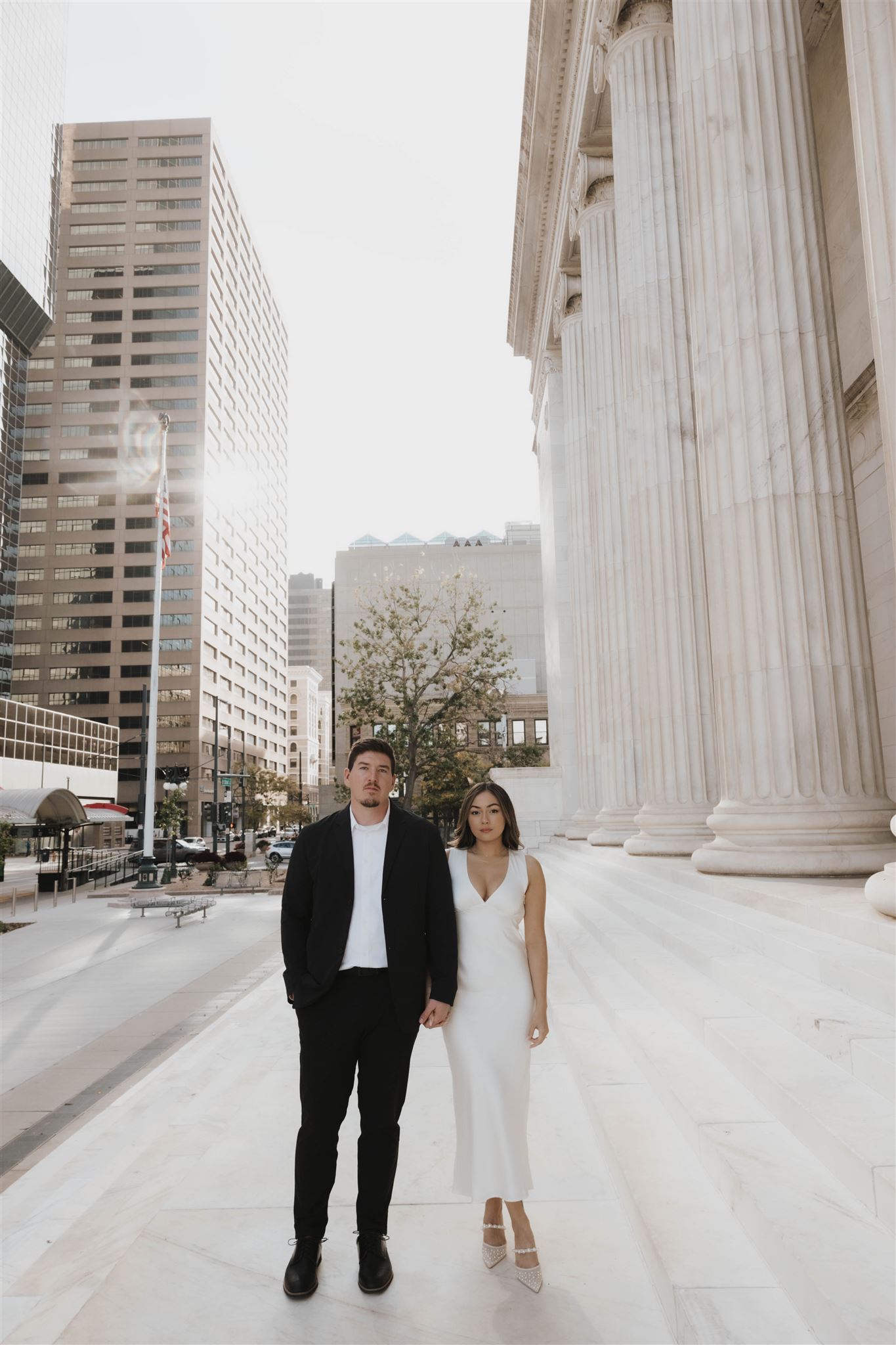 a man and woman holding hands on the side of the courthouse in Denver 