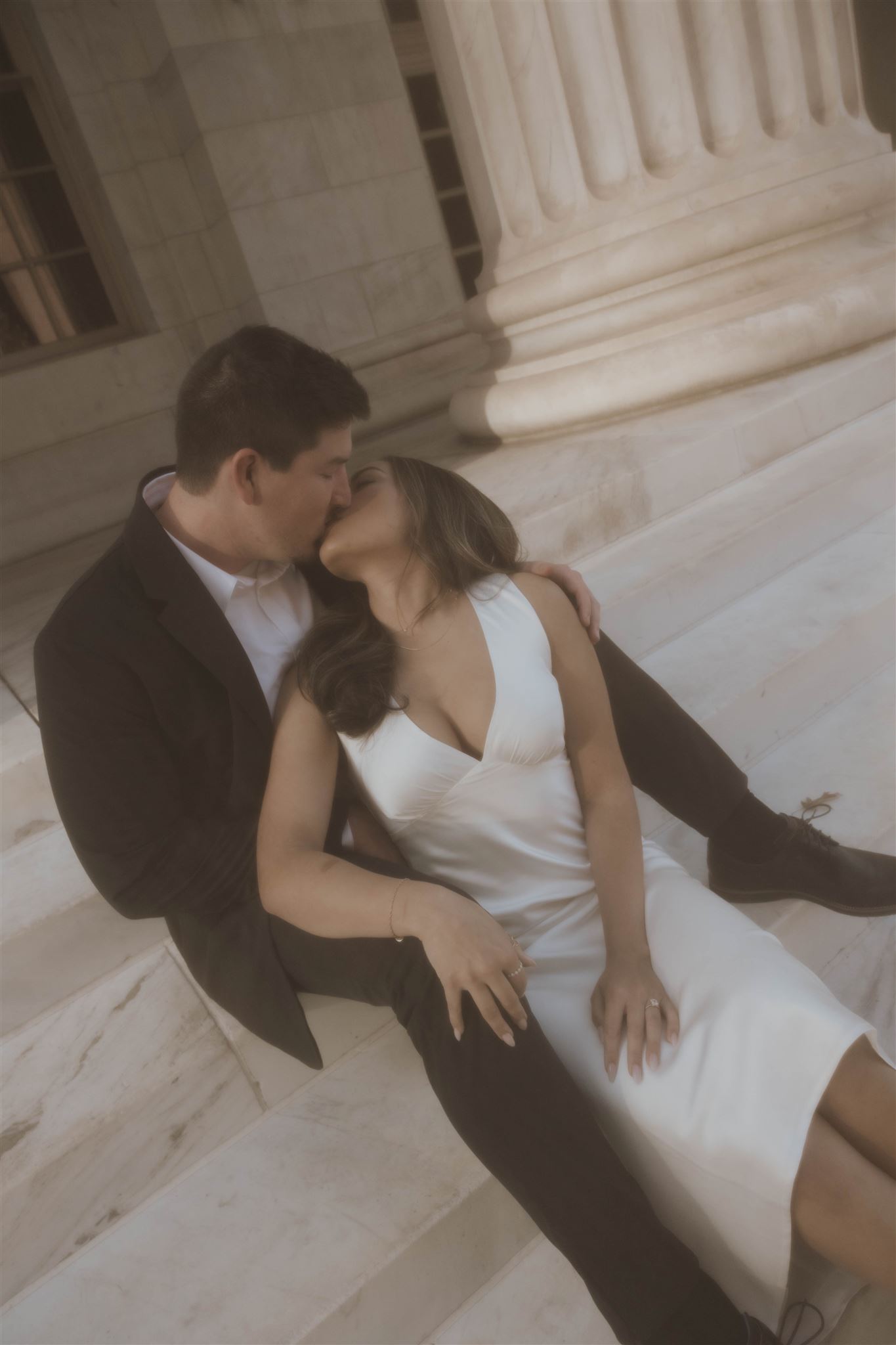 a vintage style engagement photo of a man and woman kissing 