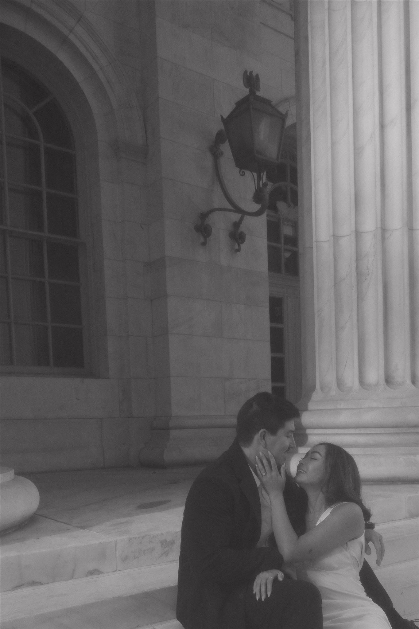 a grainy/vintage photo of a man and woman sitting on the courthouse steps