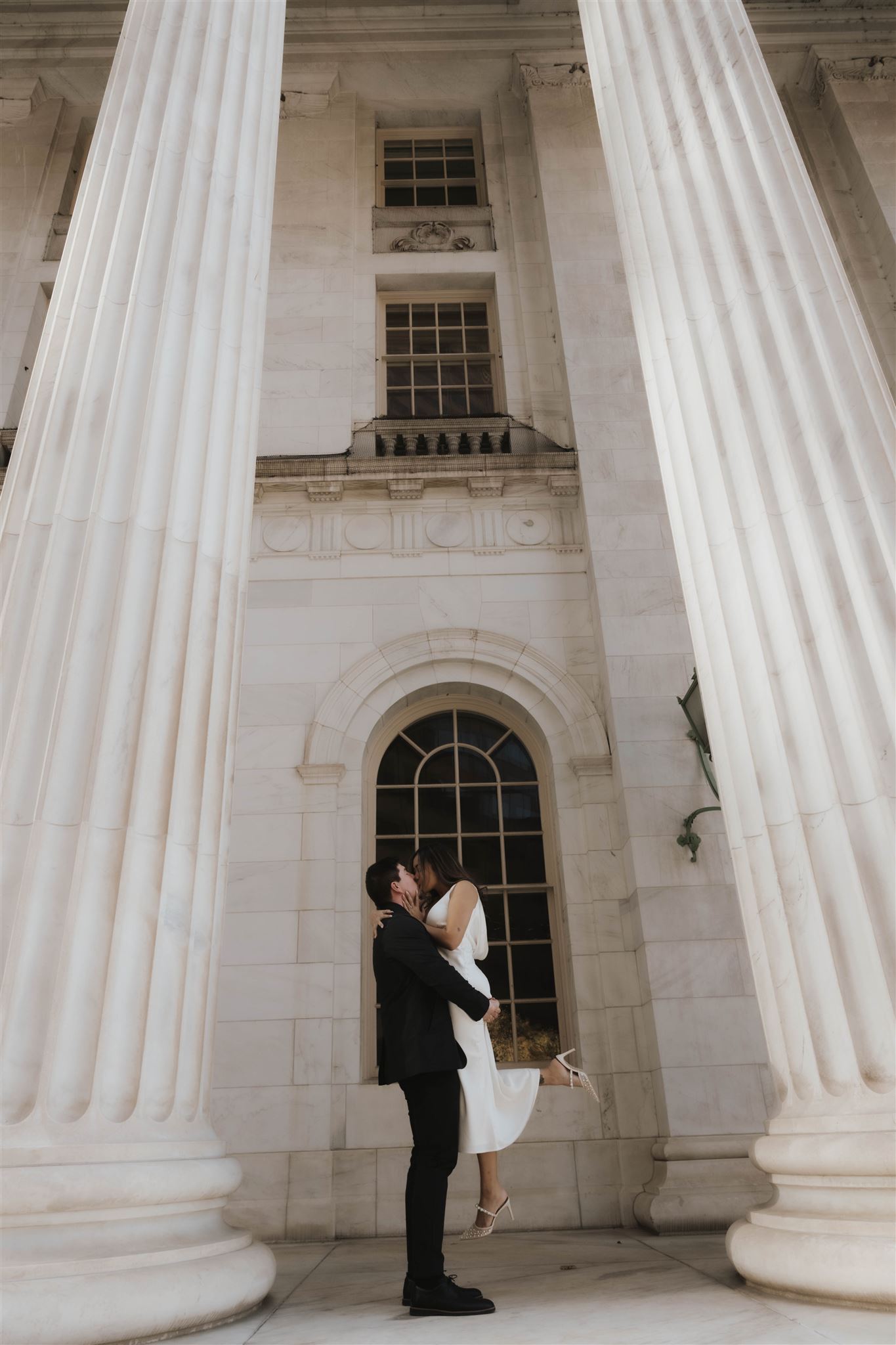 a man holding up a woman and kissing her during their Elegant Engagement Photos