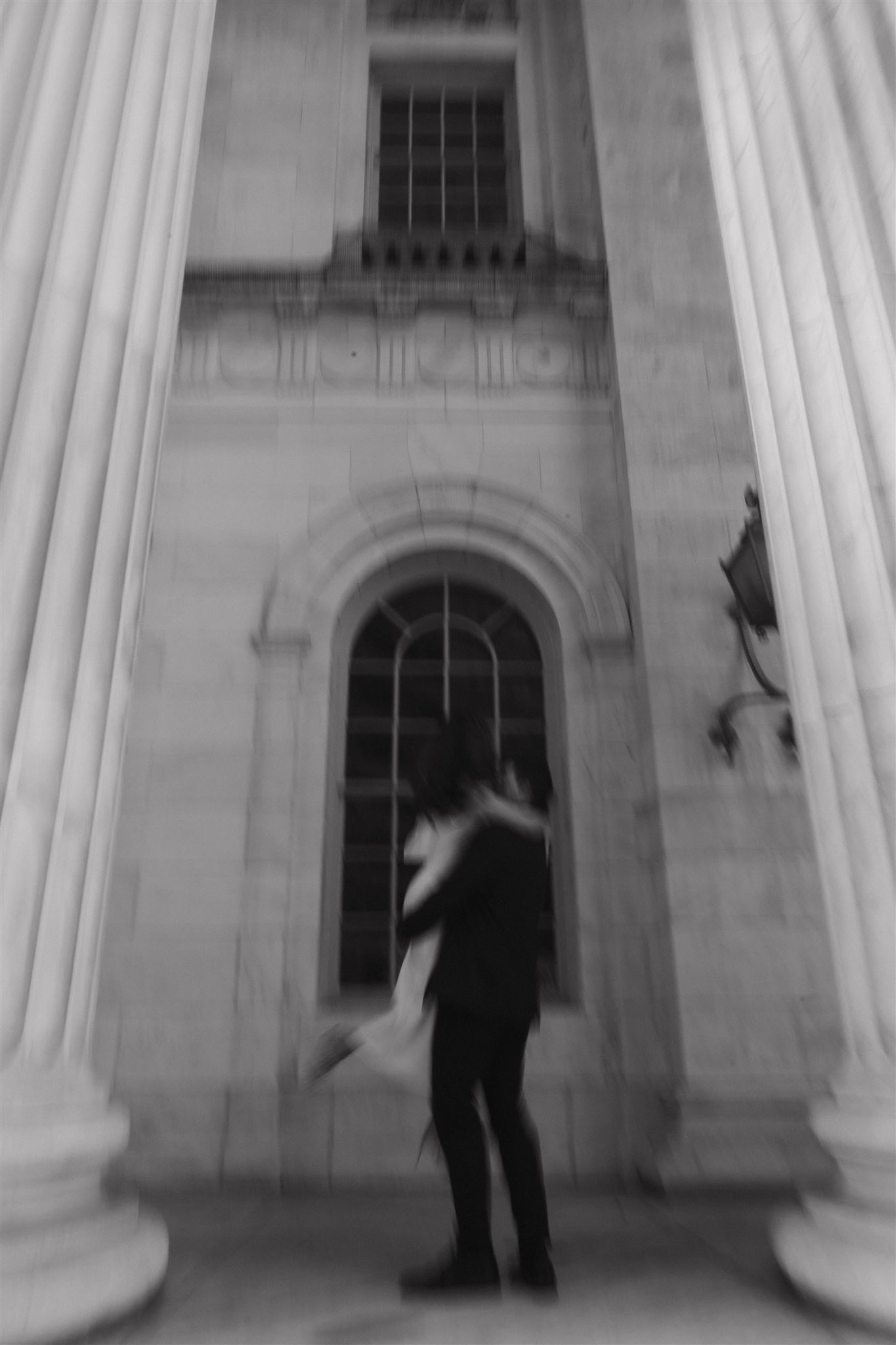 a black and white blurry photo of a man spinning a woman around during their Elegant Engagement Photos