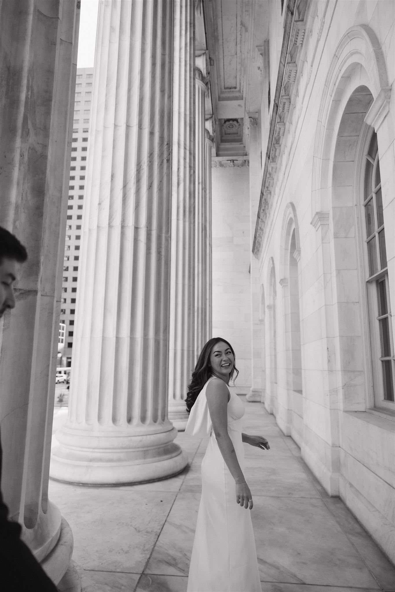 a woman walking ahead of a man and looking back at him smiling during their Elegant Engagement Photos