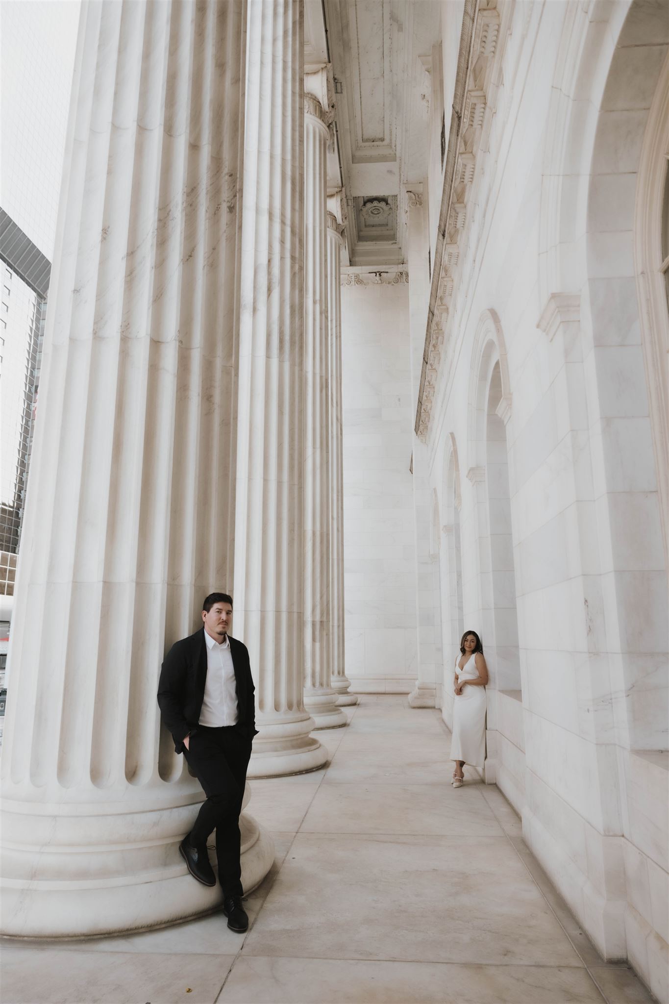 a man and woman posing outside the Denver courthouse for Elegant Engagement Photos