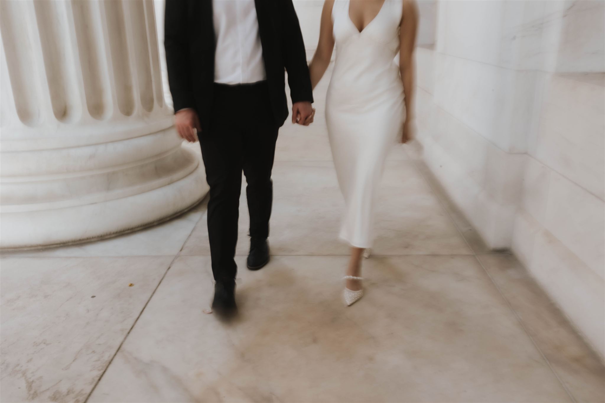 a blurry and aesthetic Elegant Engagement Photo of the couple walking hand in hand from the waist down 