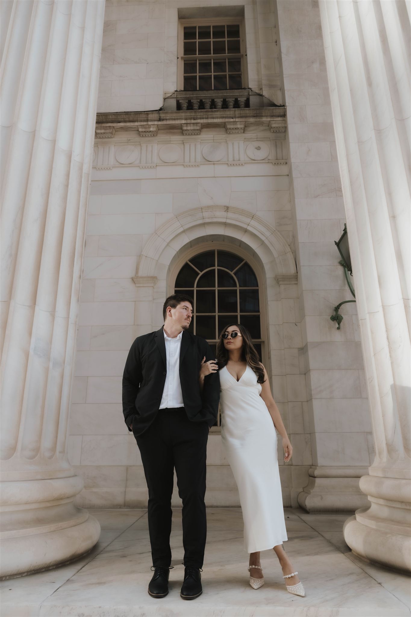 a woman wearing chic sunglasses standing with her soon to be husband for their Elegant Engagement Photos