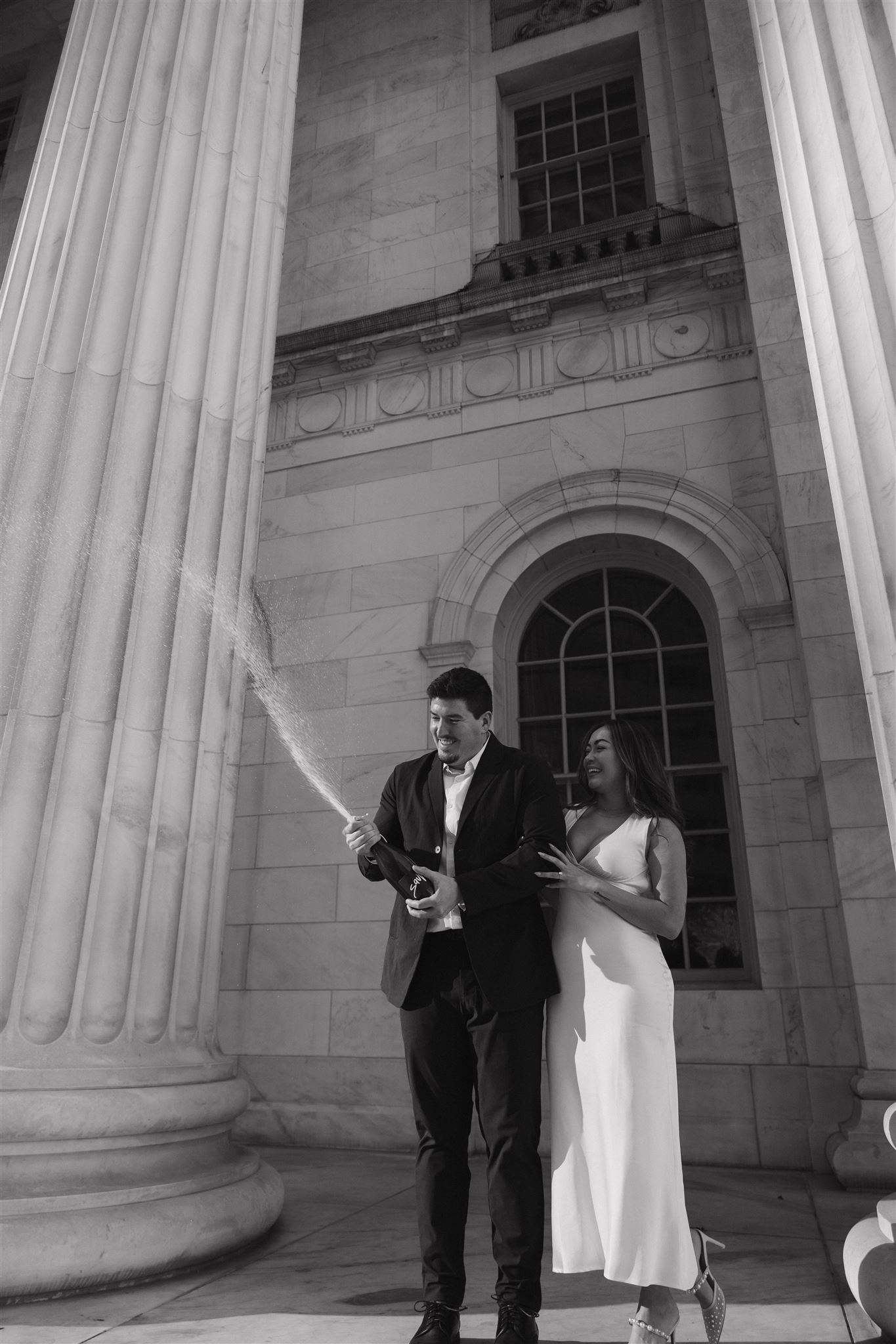 a man popping champagne with his soon to be wife during their Elegant Engagement Photos