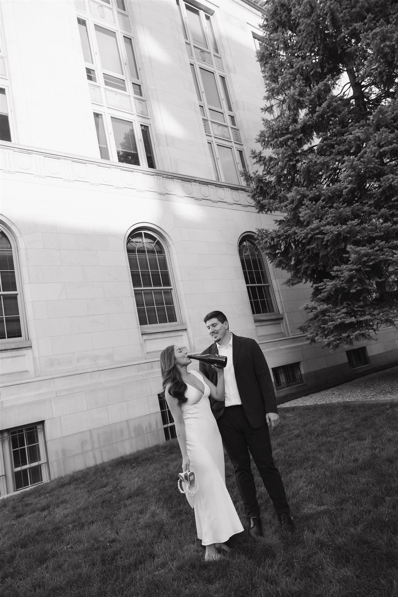 a woman taking a drink of the champagne during their Elegant Engagement Photos