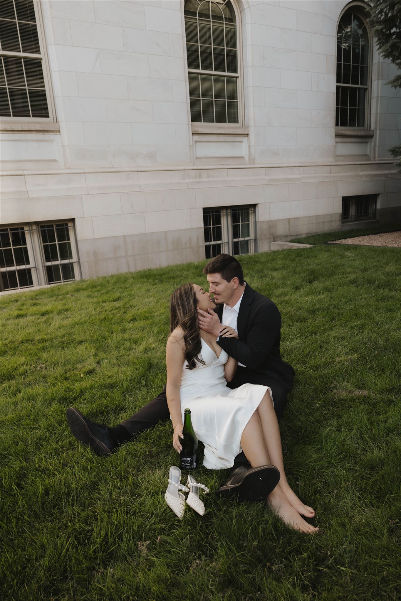 a man and woman sitting in the grass together during their Elegant Engagement Photos