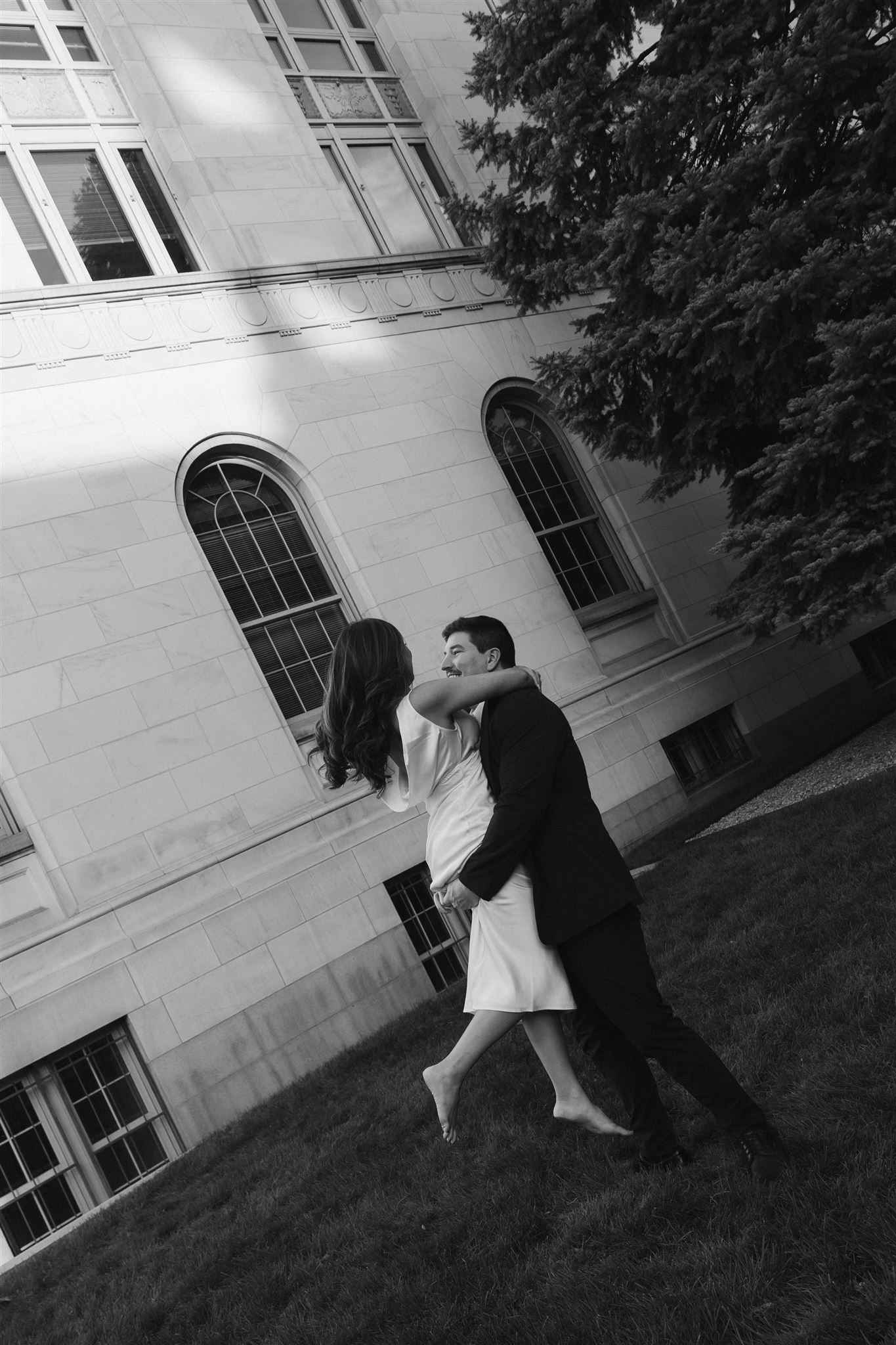 a man picking up a woman and spinning her during their Elegant Engagement Photos