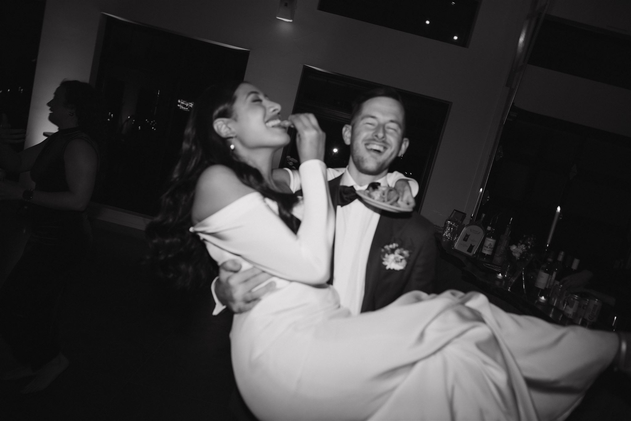 groom carrying the bride as she eats fries 