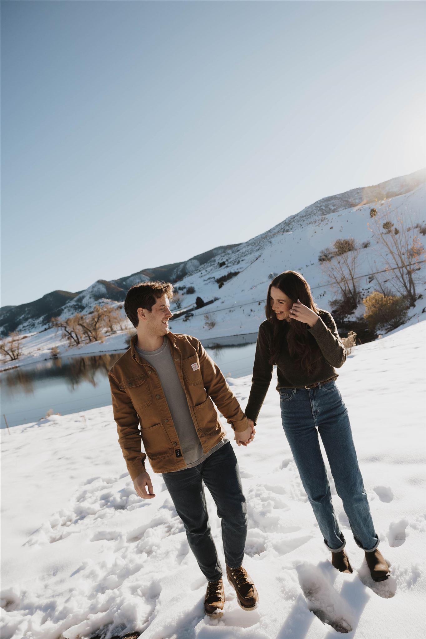 newly engaged couple holding hands during their Snowy Engagement Photos