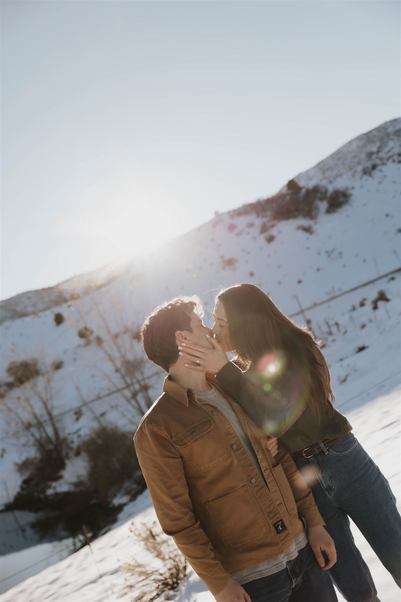 a man and woman kissing in the snow 