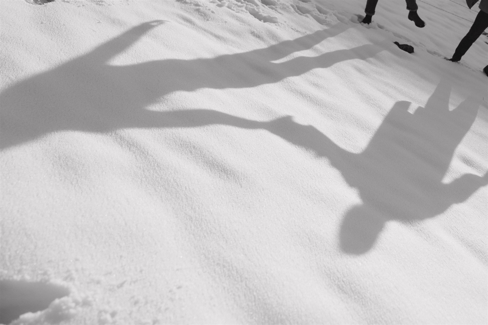 the shadows of a couple on the snow during their Snowy Engagement Photos