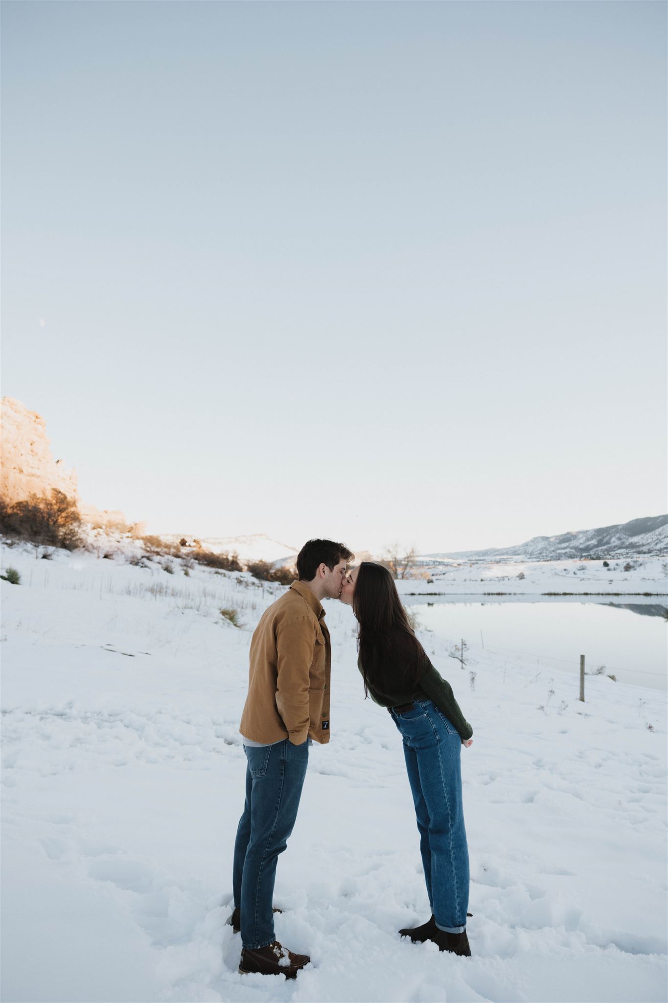 a couple leaning in to kiss during their Snowy Engagement Photos