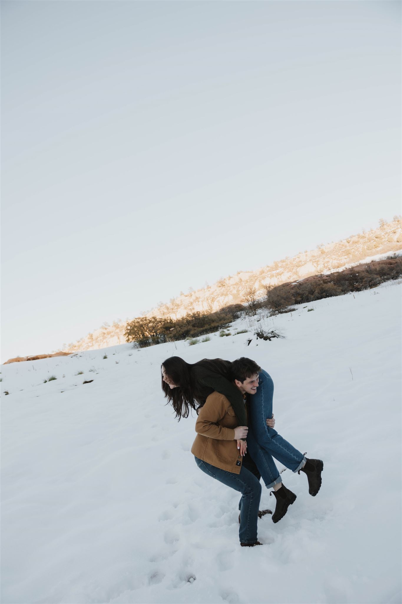 a man picking a woman up to put on his shoulder