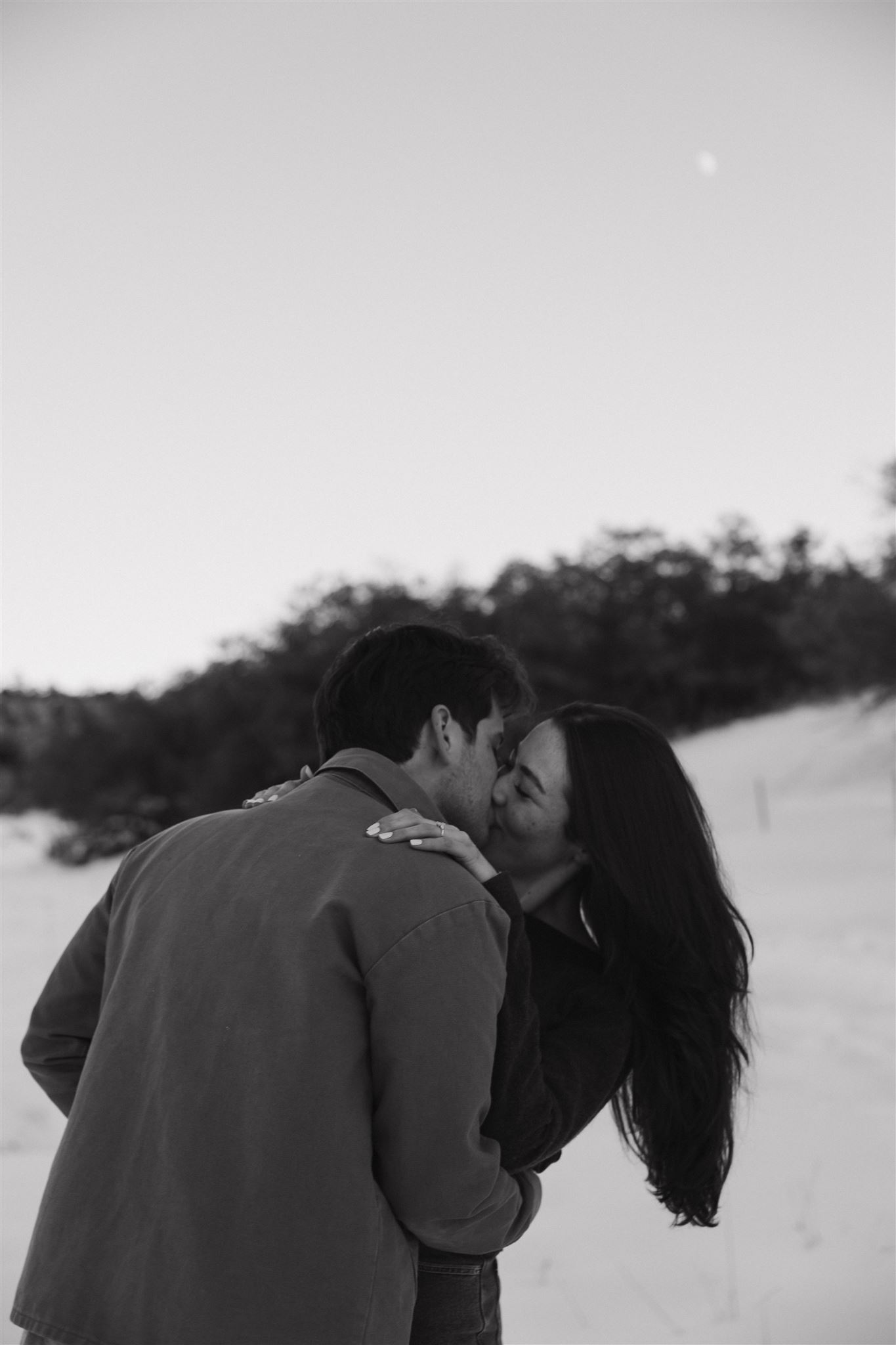 a couple kissing in the snow 