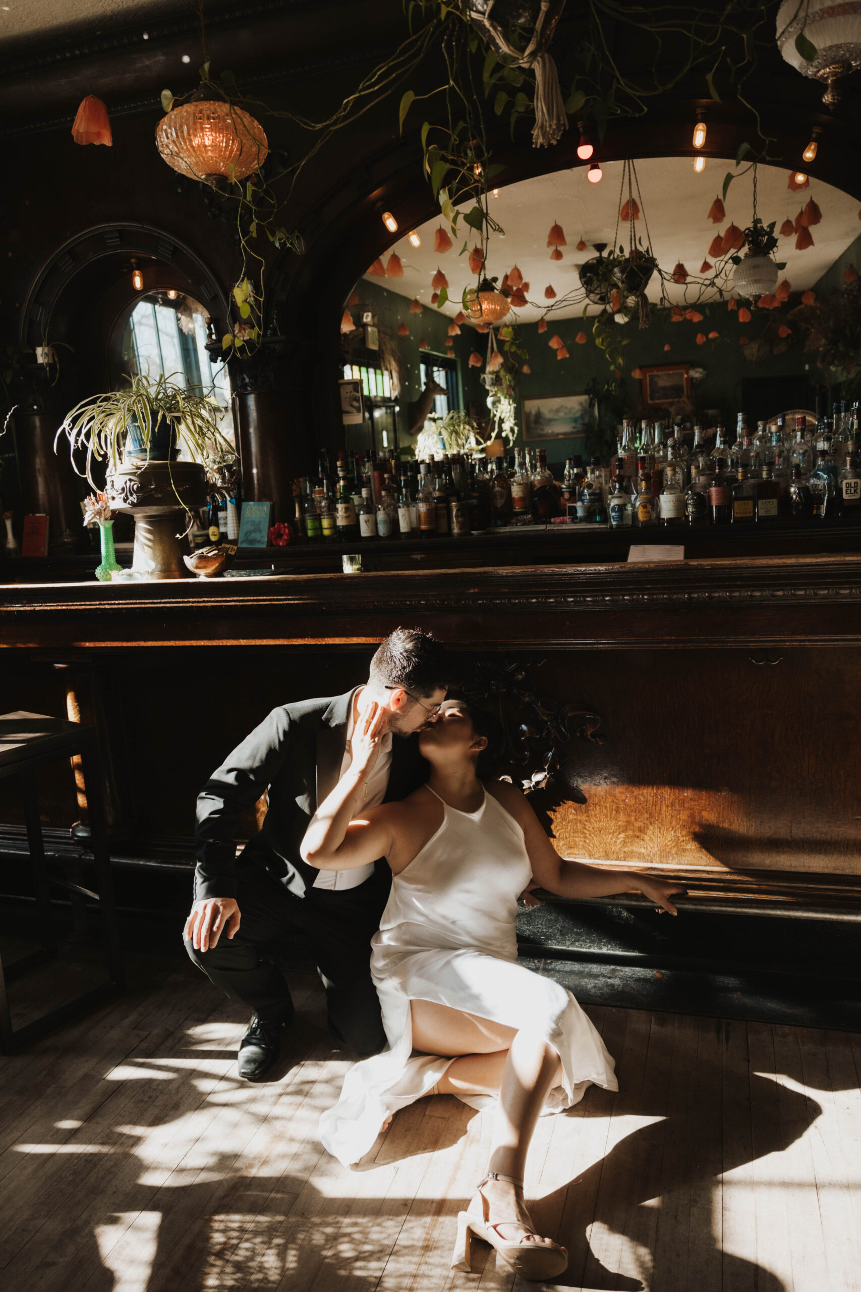 a couple sitting on the floor during their bar engagement photos in Colorado 