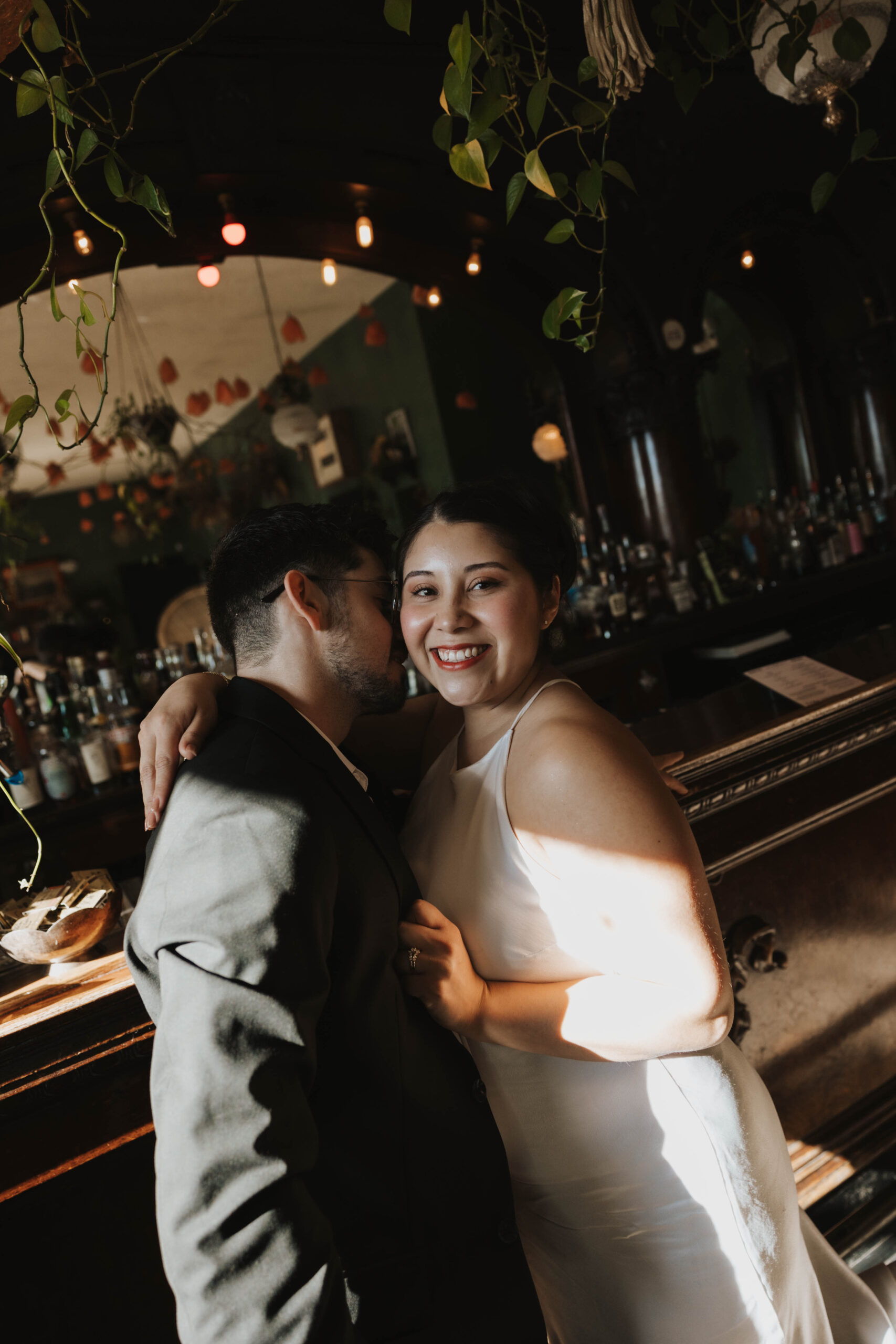 a man kissing a woman's neck at a bar during engagement photos 