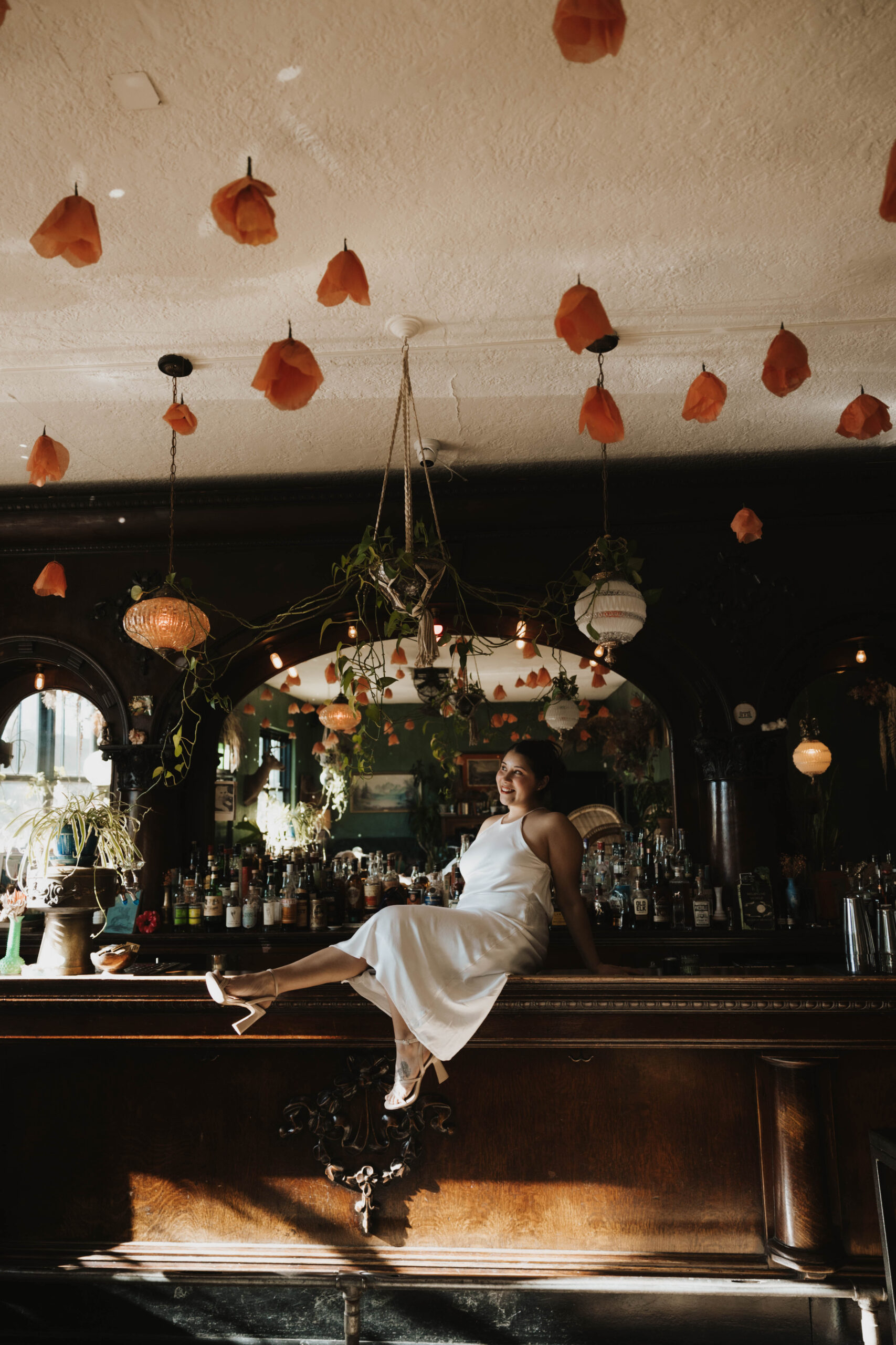 a woman sitting on a bar at her Denver Engagement Photo Location