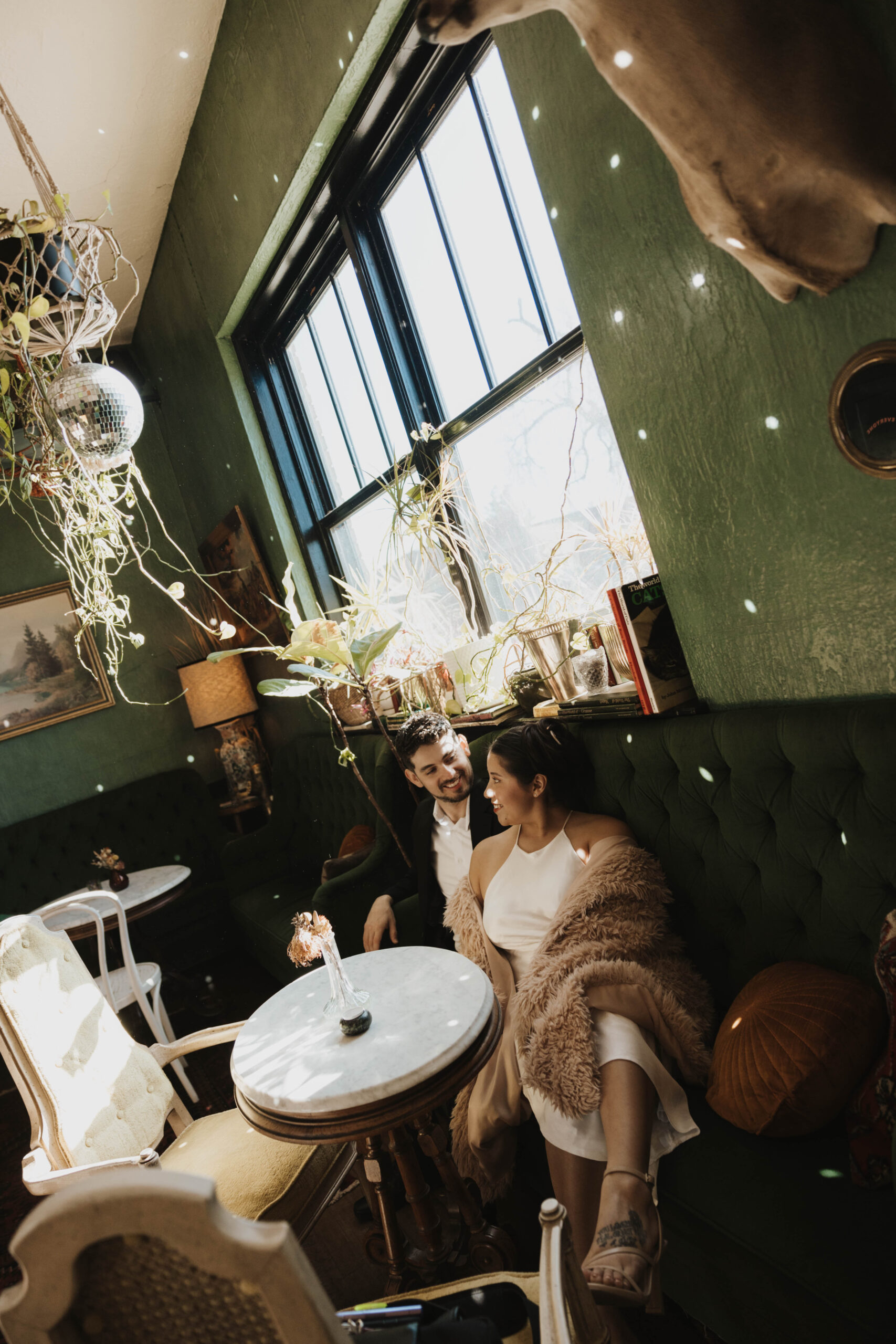 a couple sitting in a booth at a bar for their Denver Engagement Photo Location