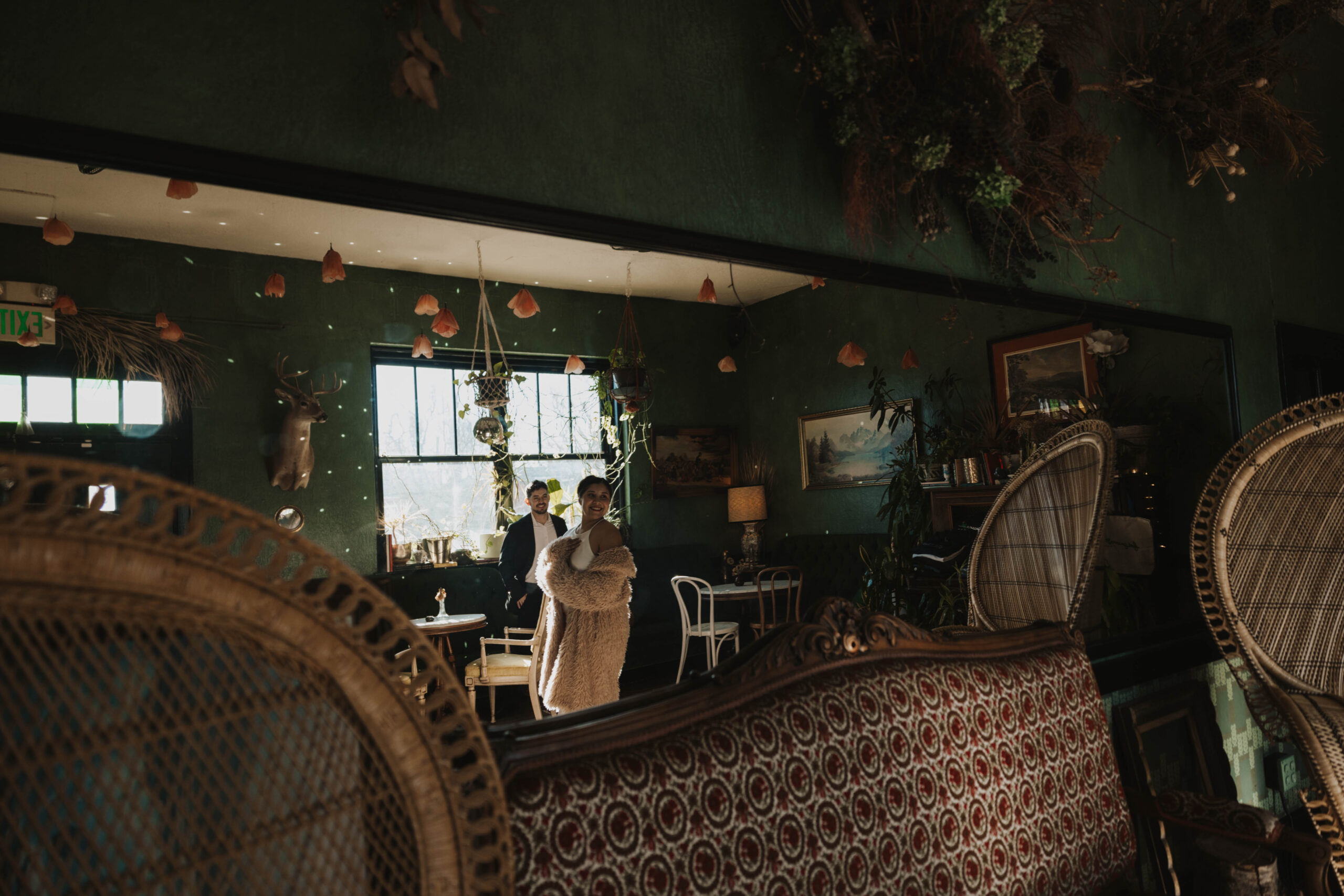 a couple through a mirror at a bar during their engagement session