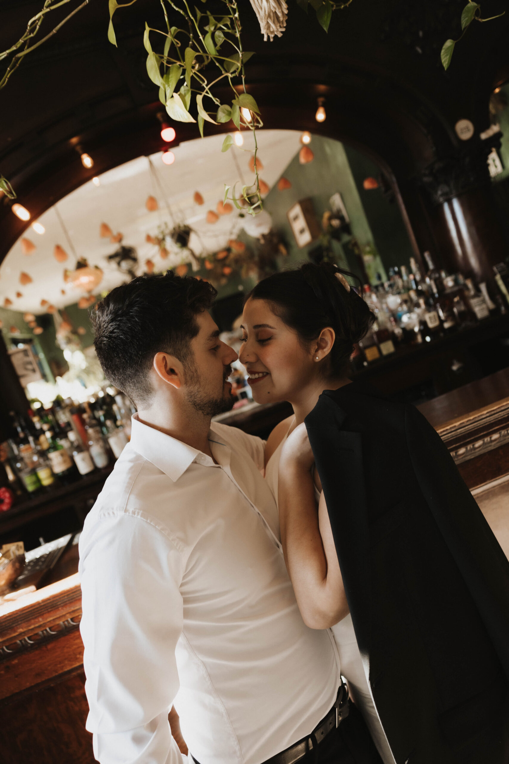 newly engaged couple smiling together at a bar for their Denver Engagement Photo Location