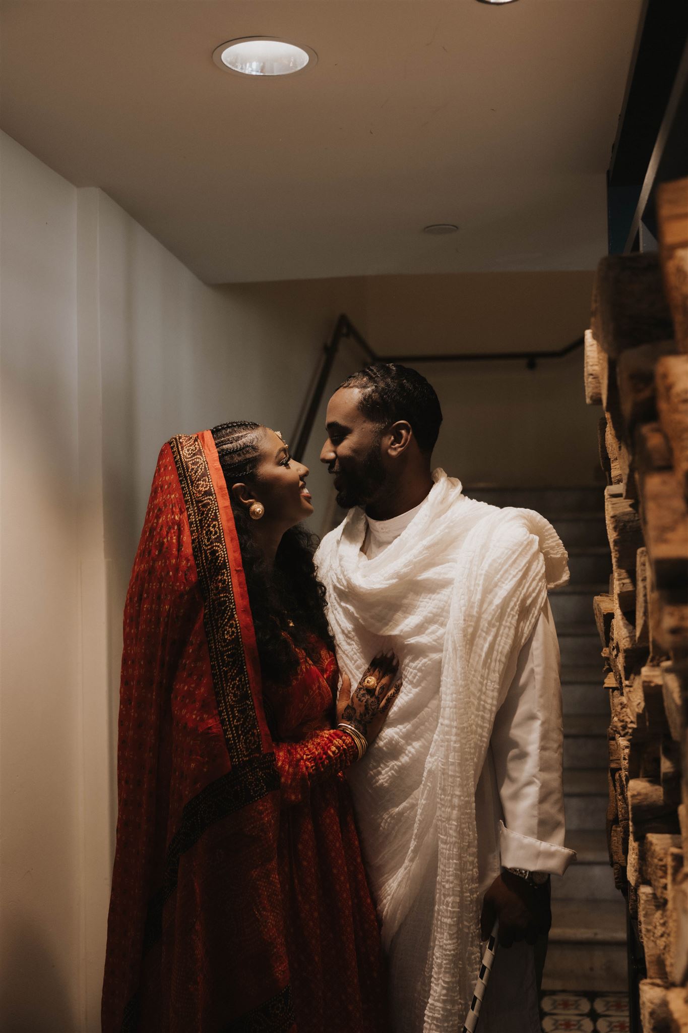 newly engaged couple smiling at each other in the stairwell 